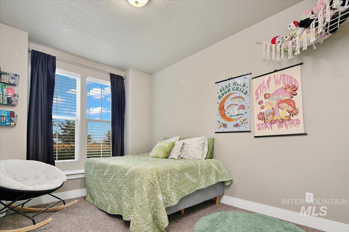 Bedroom featuring a textured ceiling and carpet