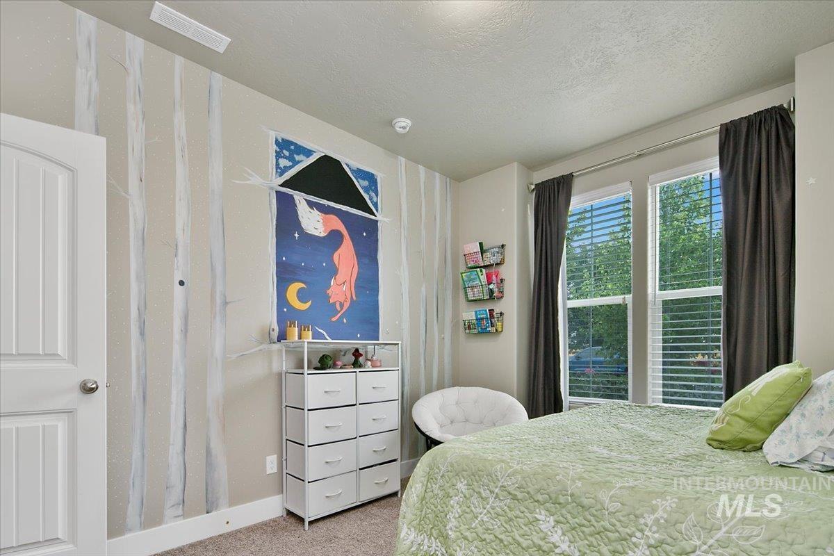 Bedroom featuring carpet and a textured ceiling