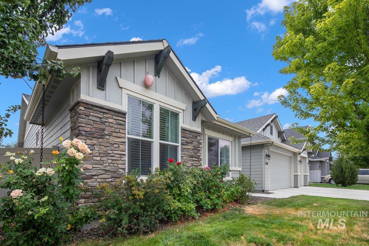 View of home's exterior with stone siding, driveway, and a garage