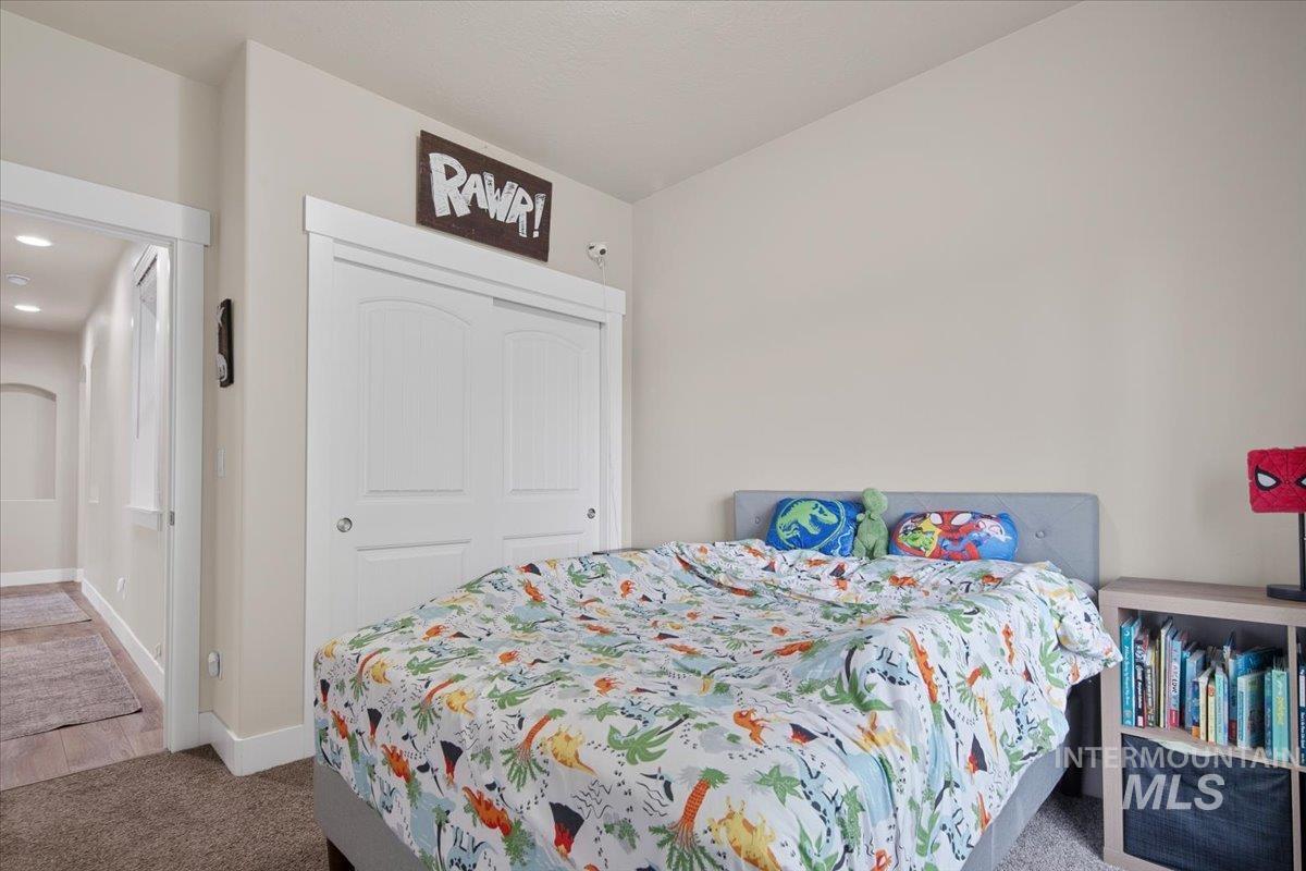 Carpeted bedroom with a closet and recessed lighting