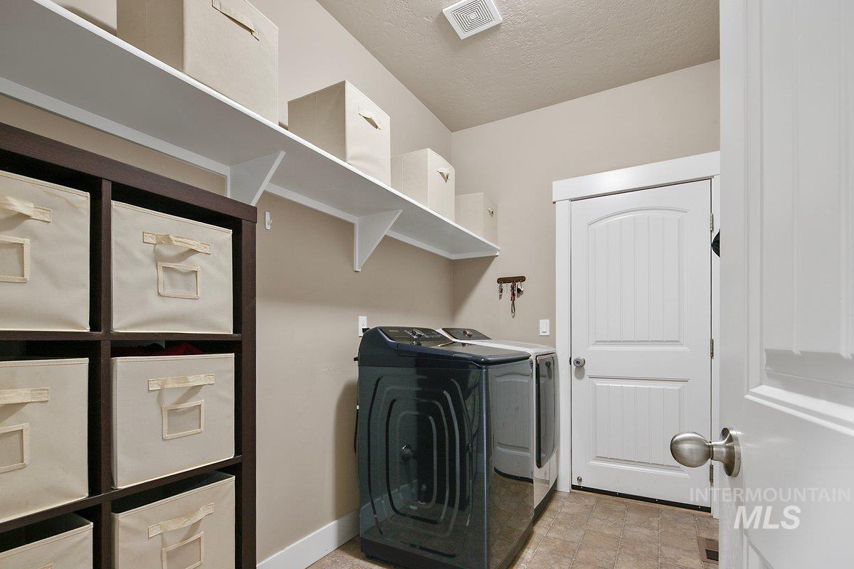 Laundry area with a textured ceiling and washing machine and dryer