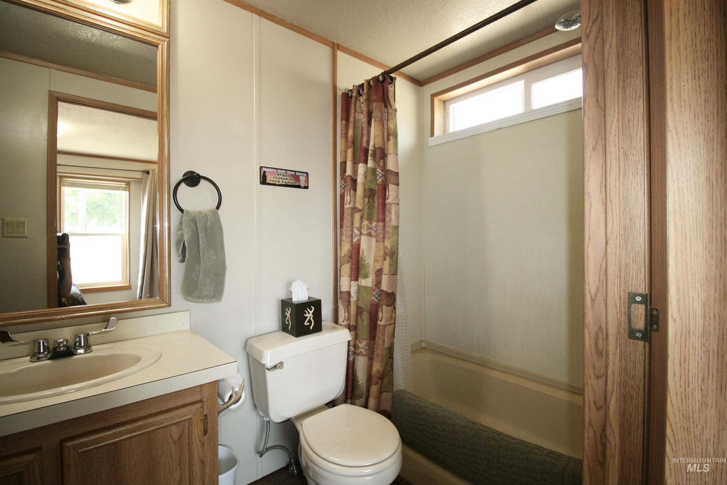 Full bathroom with shower / tub combo with curtain and vanity