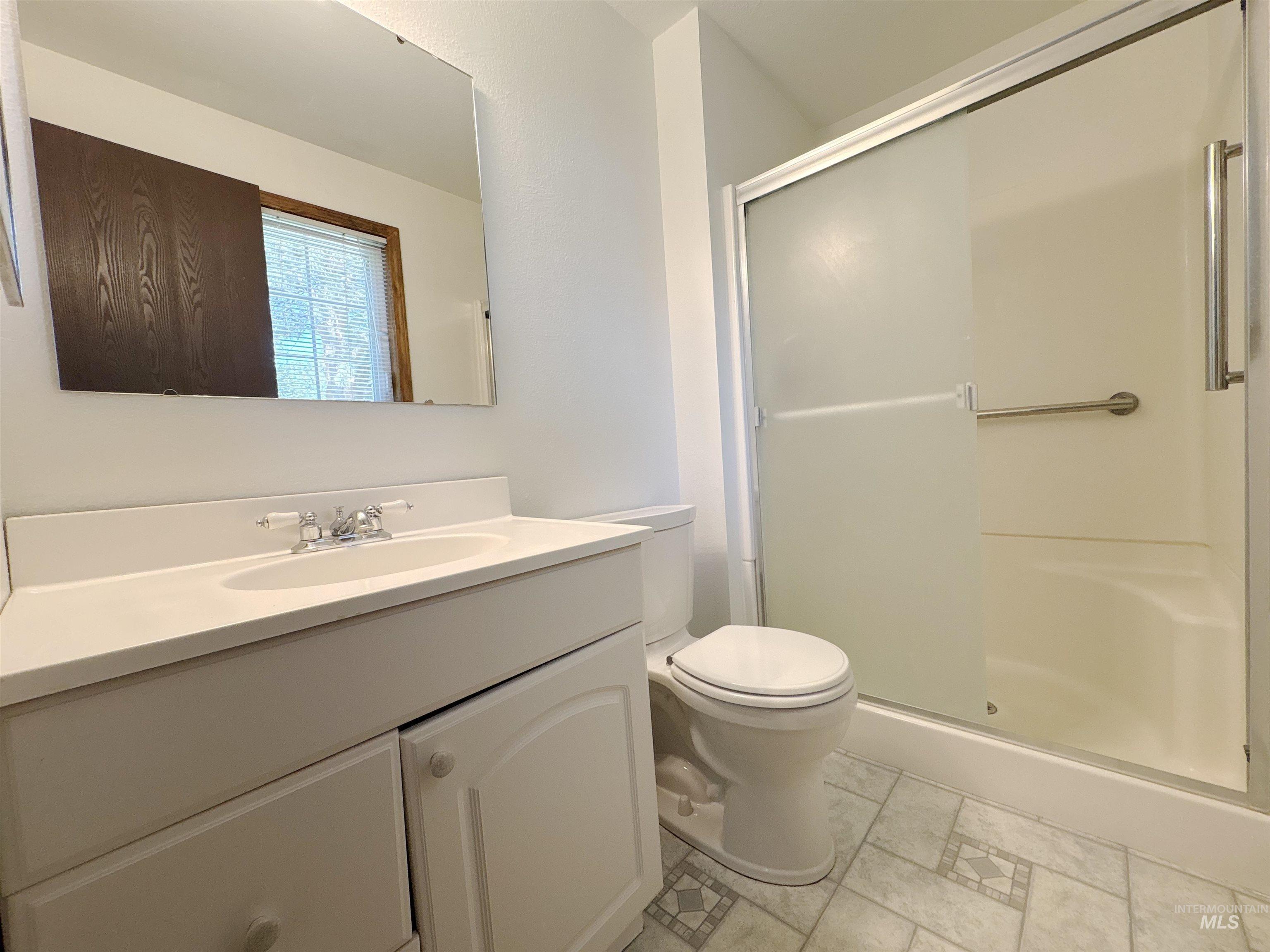 Full bath featuring vanity and a shower stall