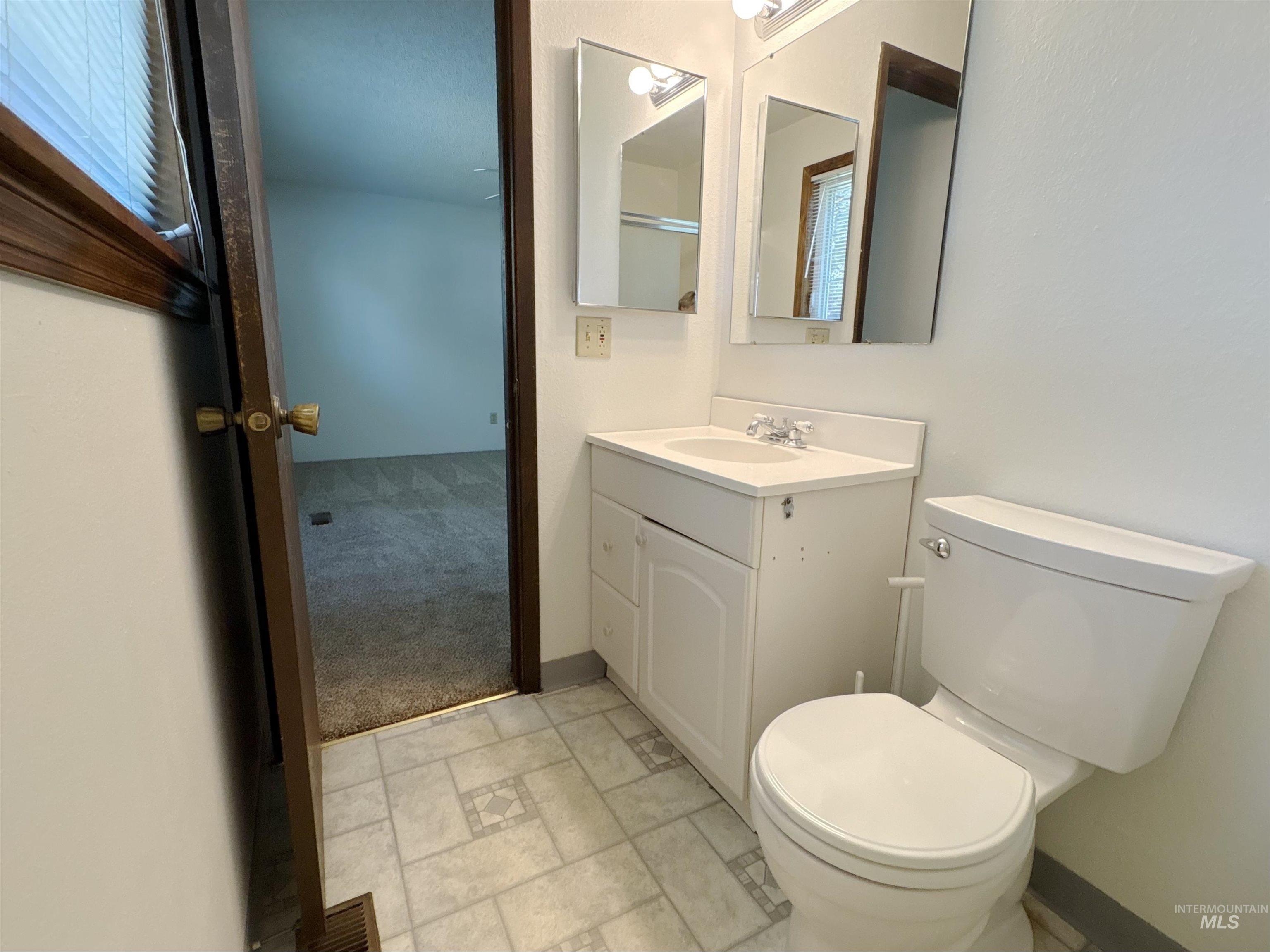 bath featuring toilet and vanity
