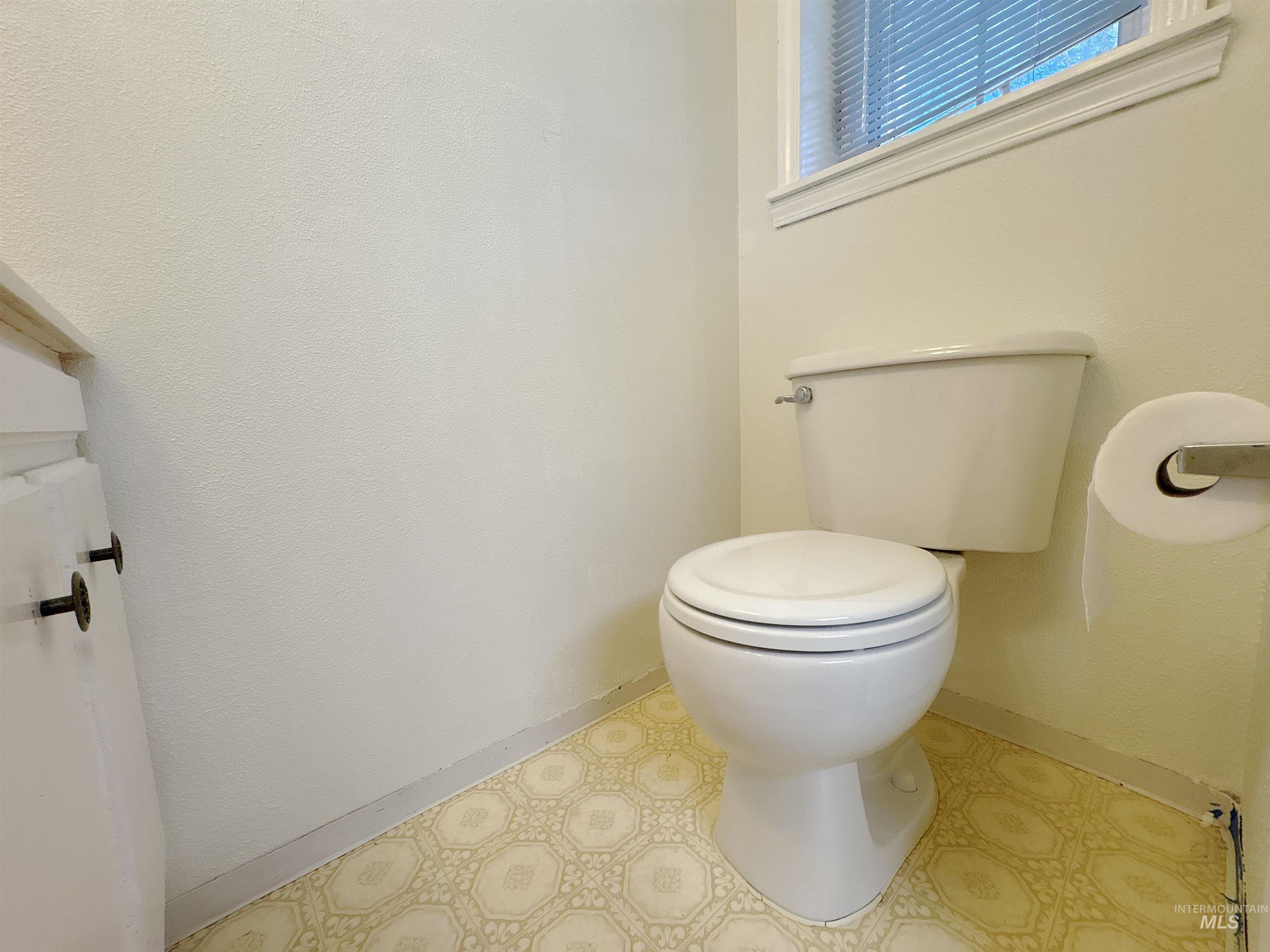 Bathroom featuring baseboards and toilet