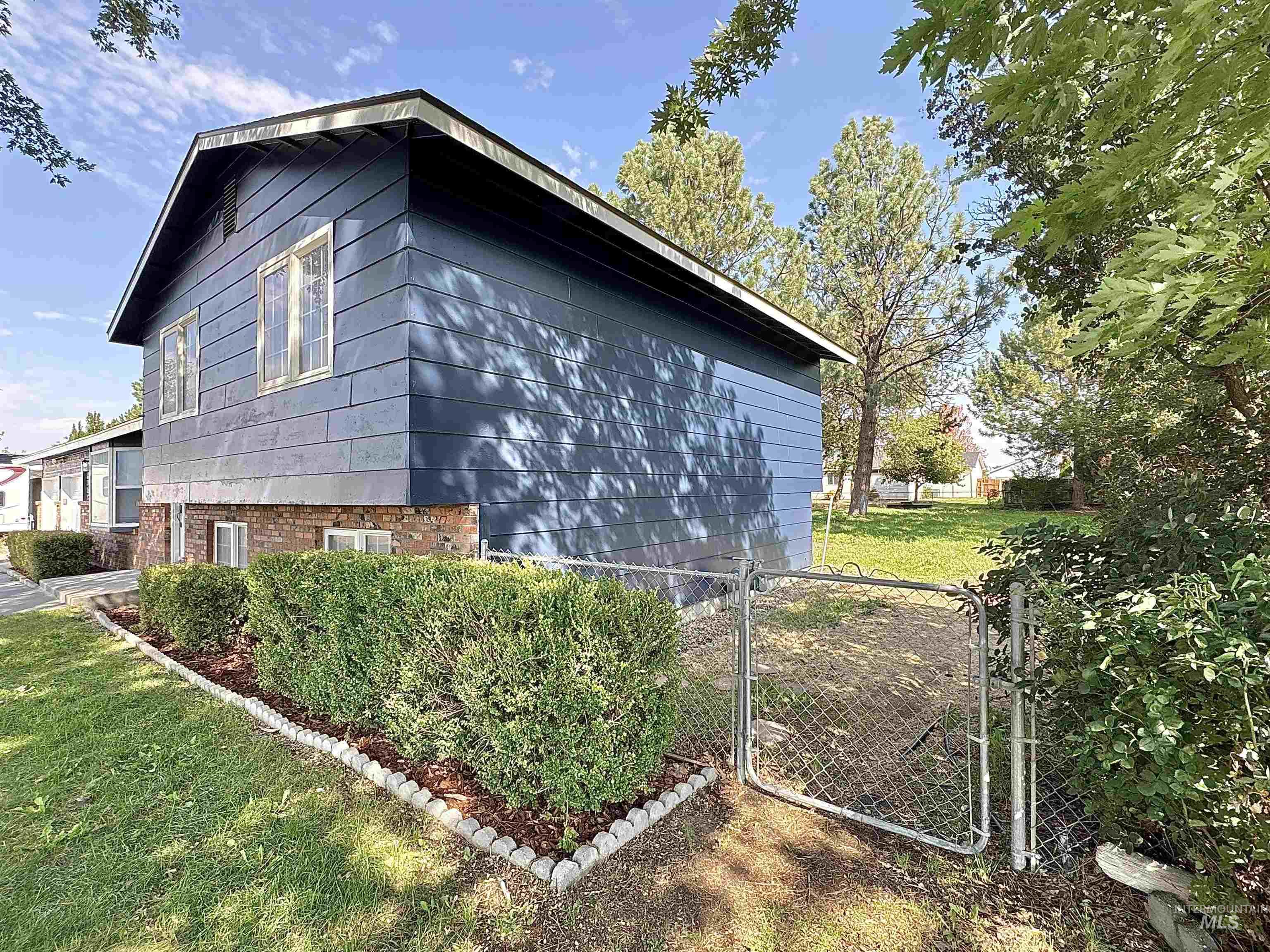 View of property exterior featuring a gate and brick siding