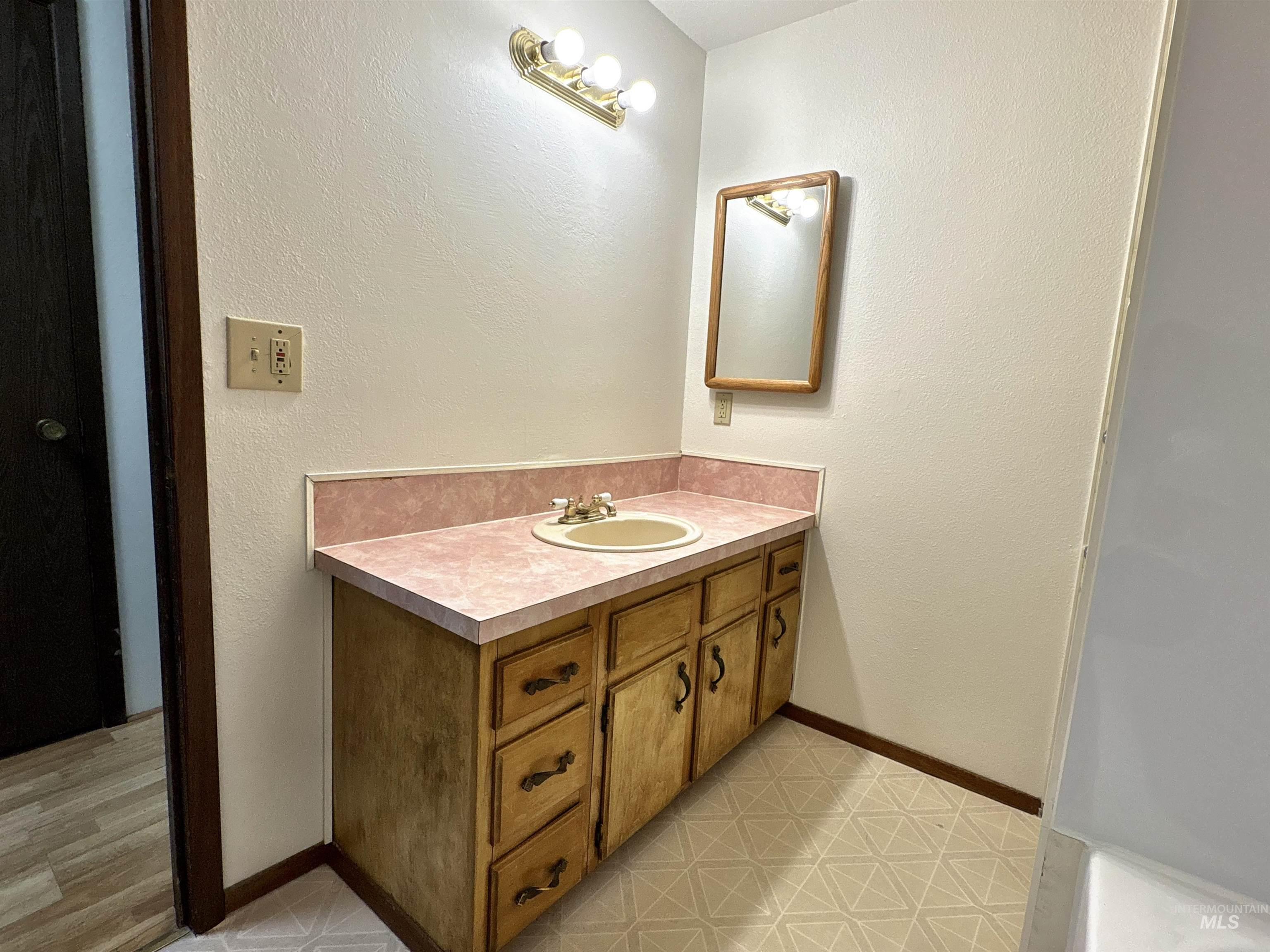 Bathroom with a textured wall and vanity