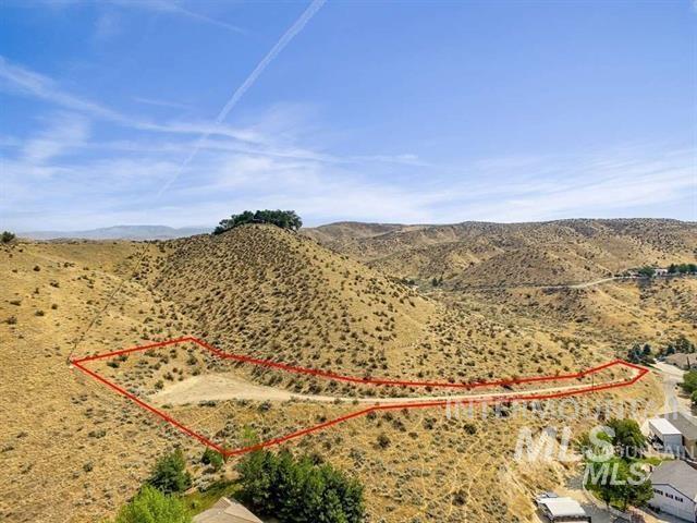 Aerial view of sparsely populated area with property boundaries highlighted and a mountain backdrop