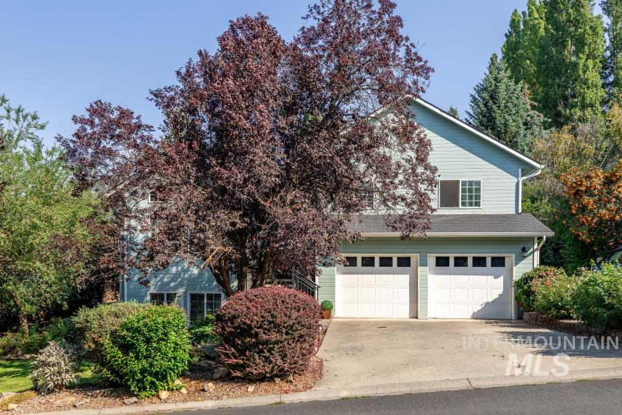 Obstructed view of property featuring concrete driveway and an attached garage