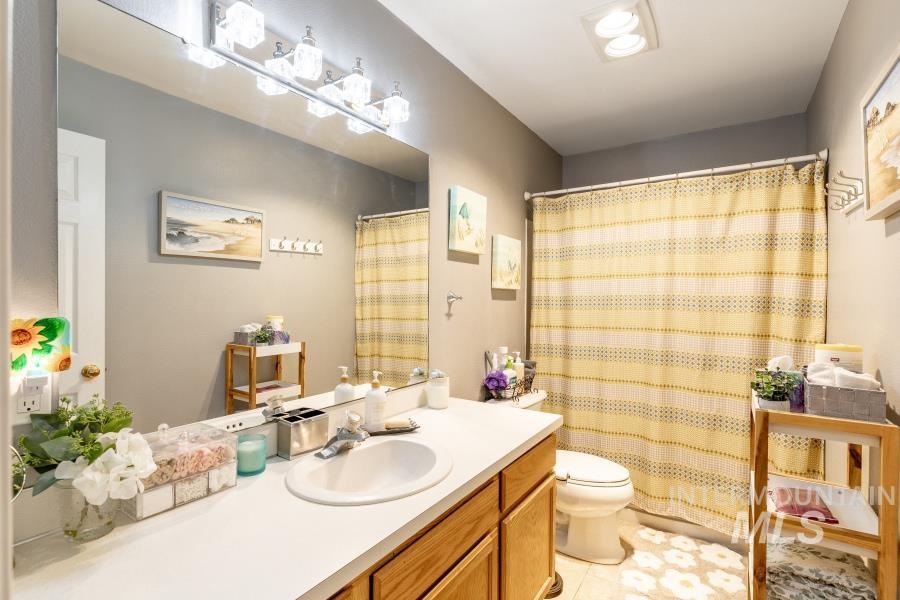 Bathroom with vanity, light tile patterned floors, and curtained shower