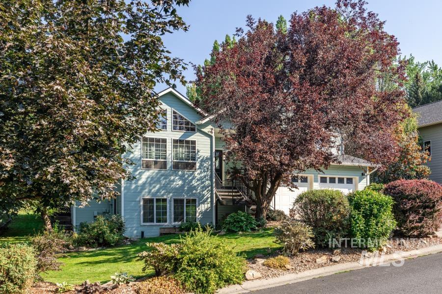 Obstructed view of property featuring a garage and a front lawn