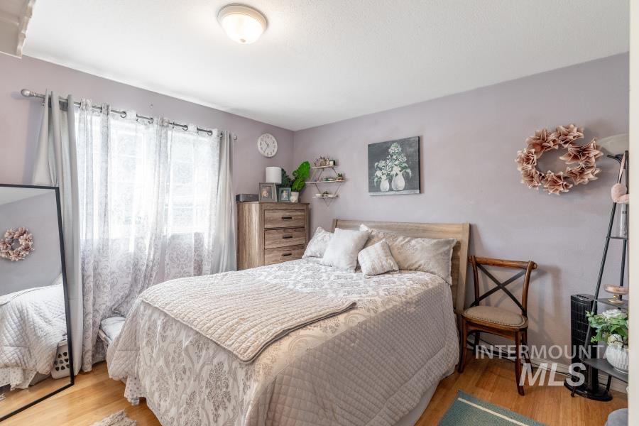 Bedroom with wood finished floors and baseboards