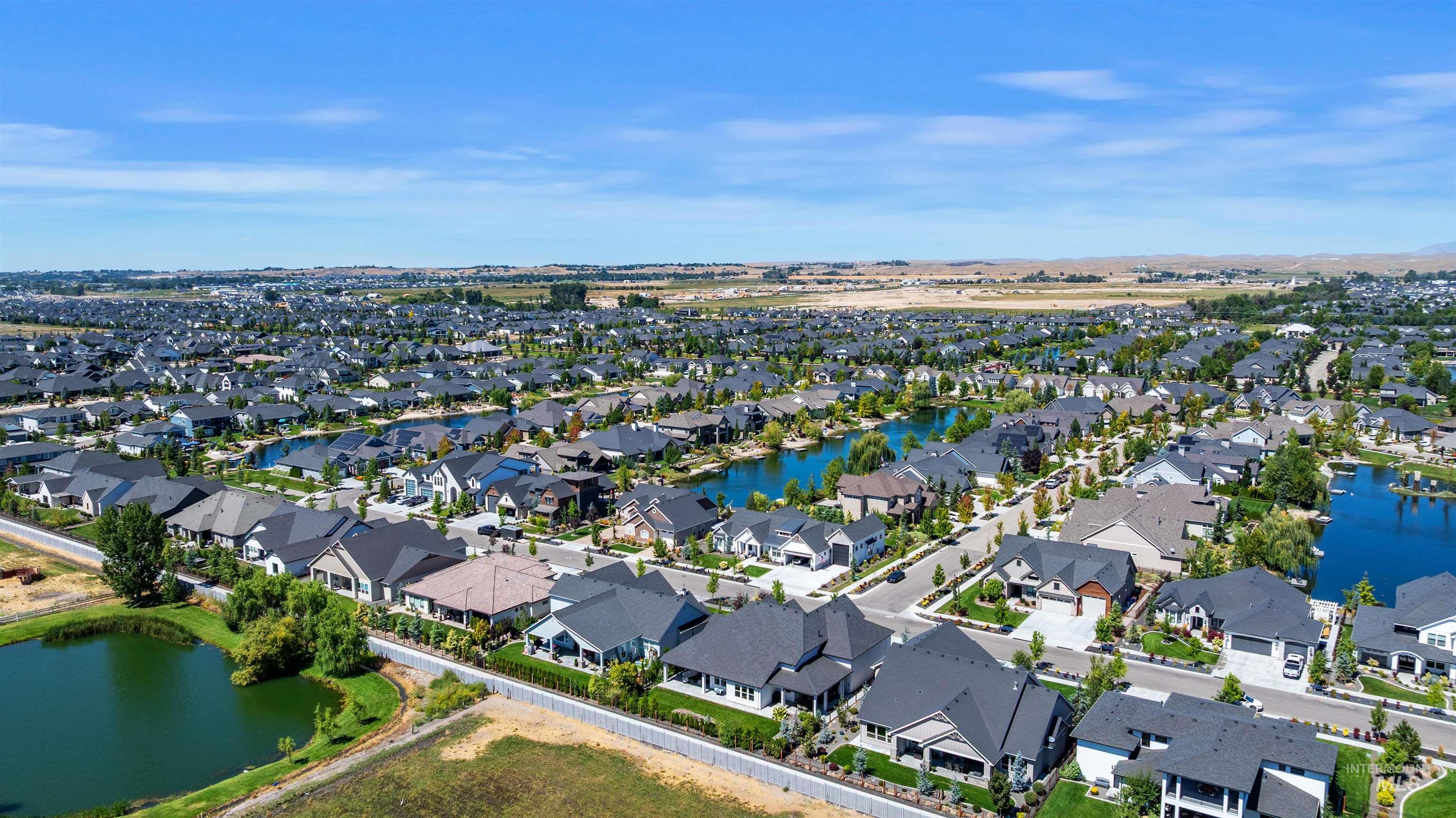 Aerial view of property and surrounding area with a large body of water and nearby suburban area