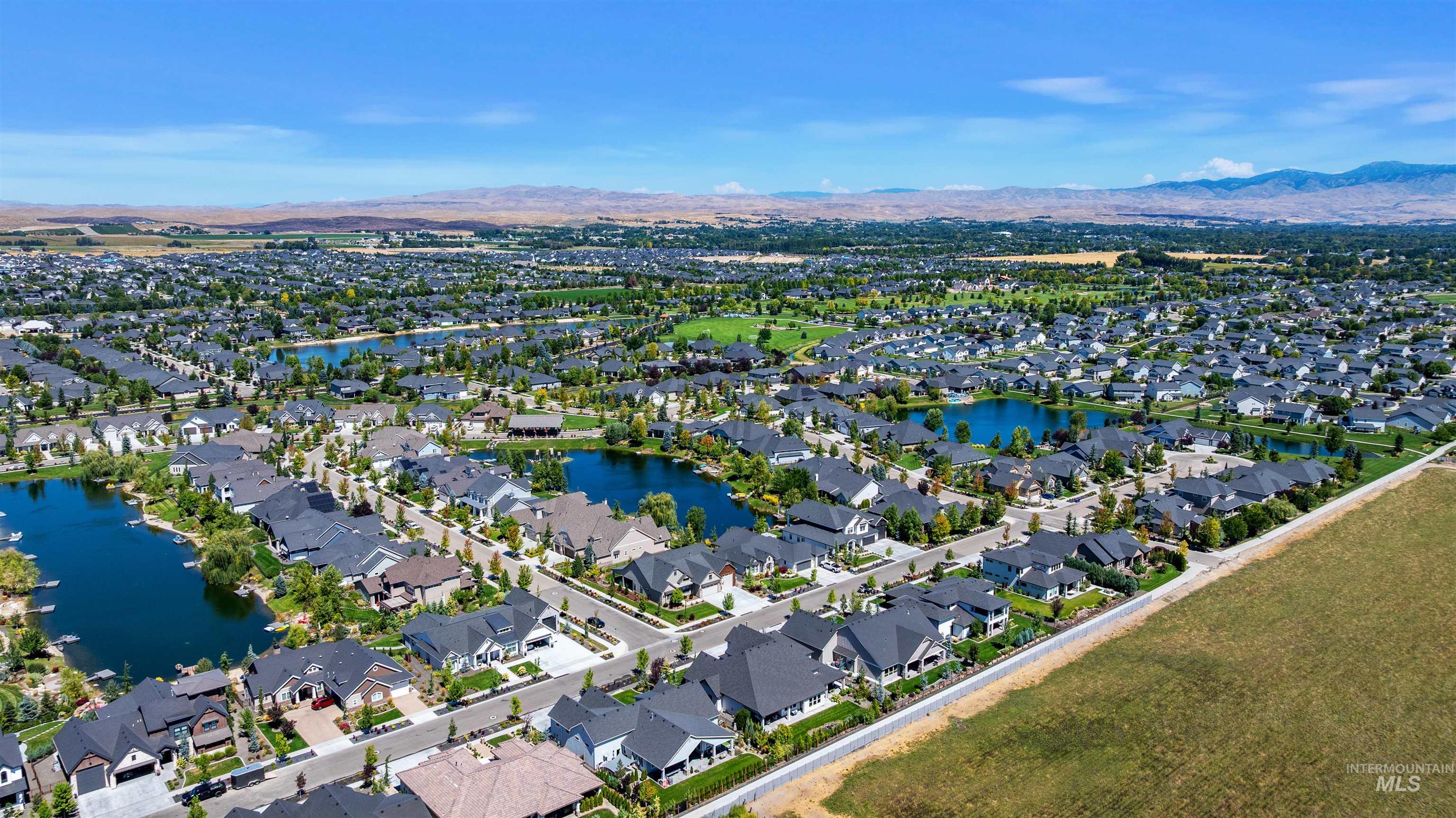Aerial view of property's location featuring a water and mountain view and nearby suburban area