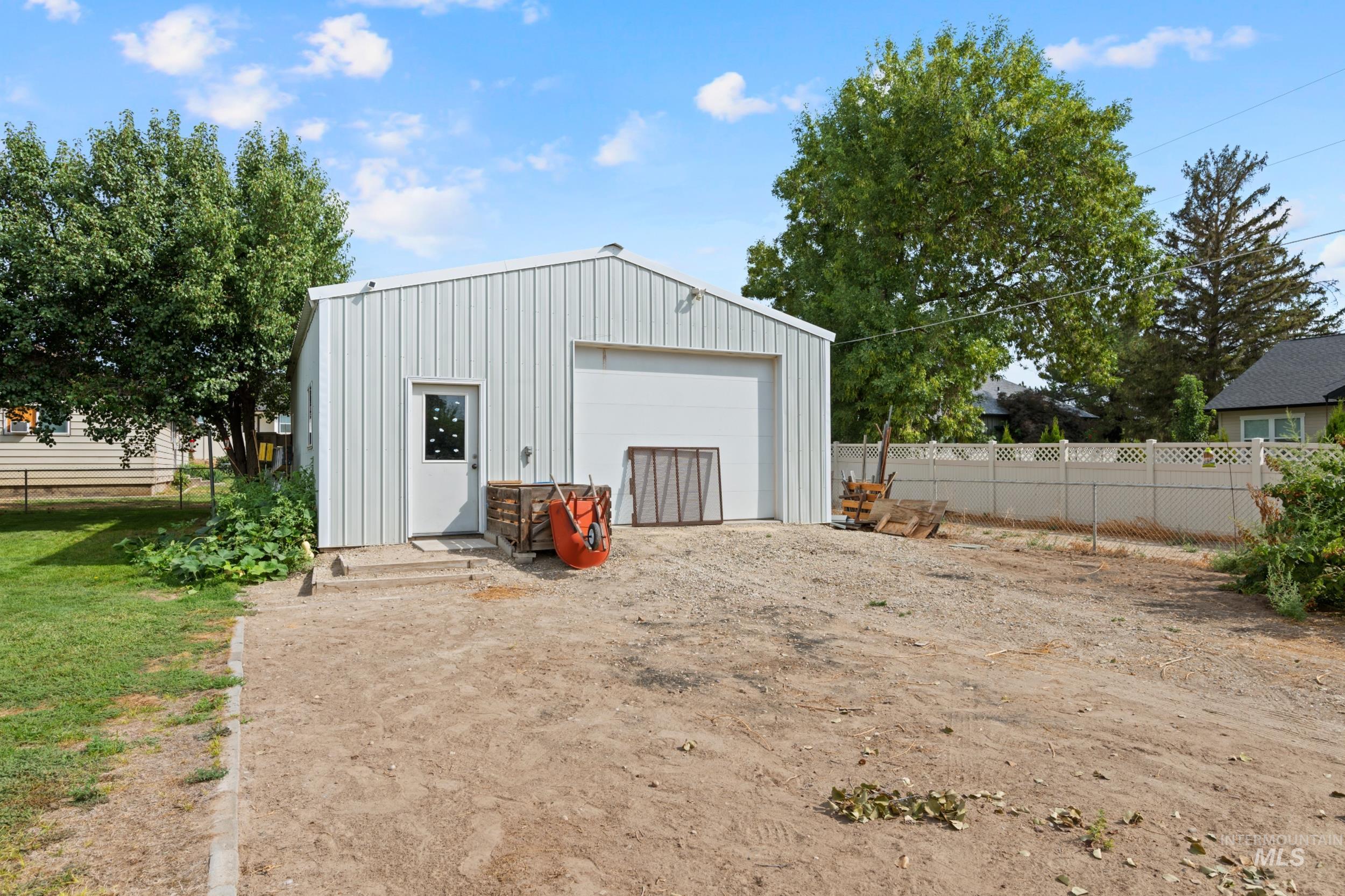 View of outdoor structure featuring dirt driveway