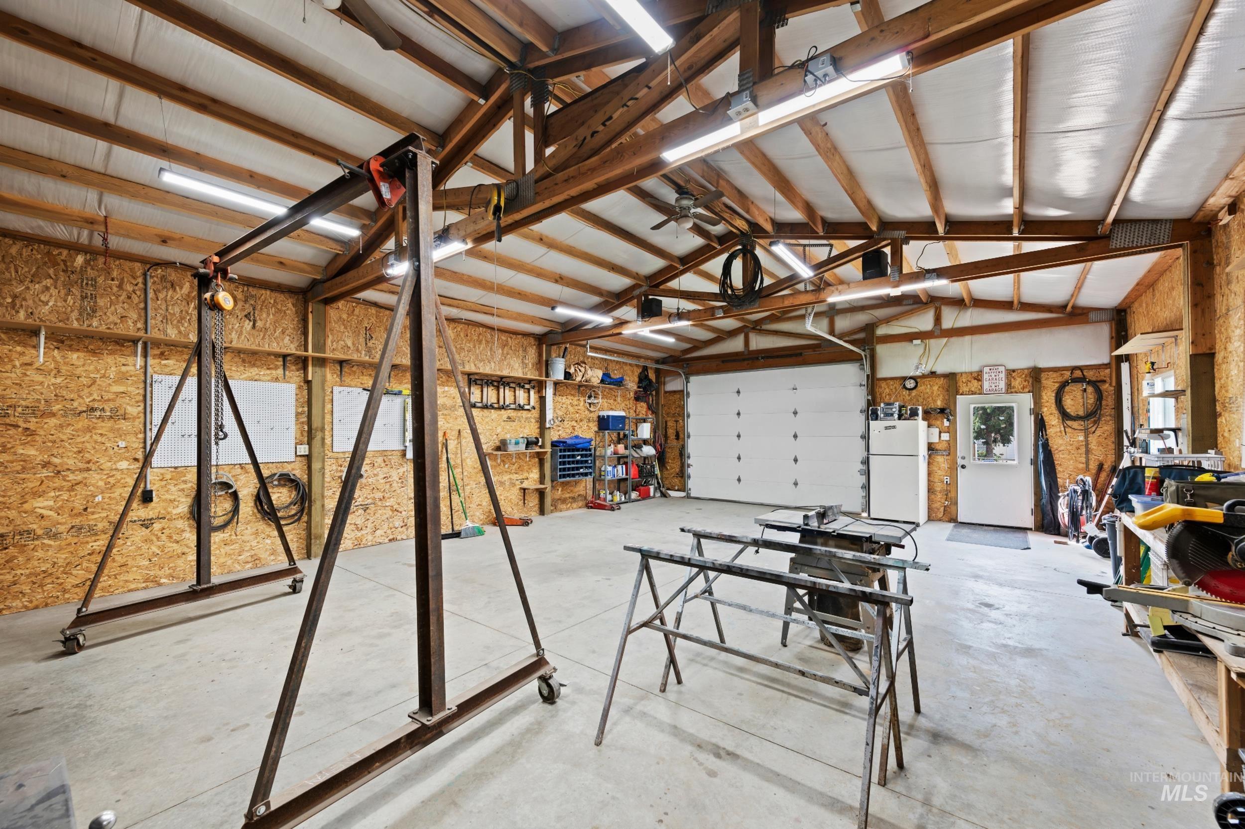 Garage with a workshop area and freestanding refrigerator