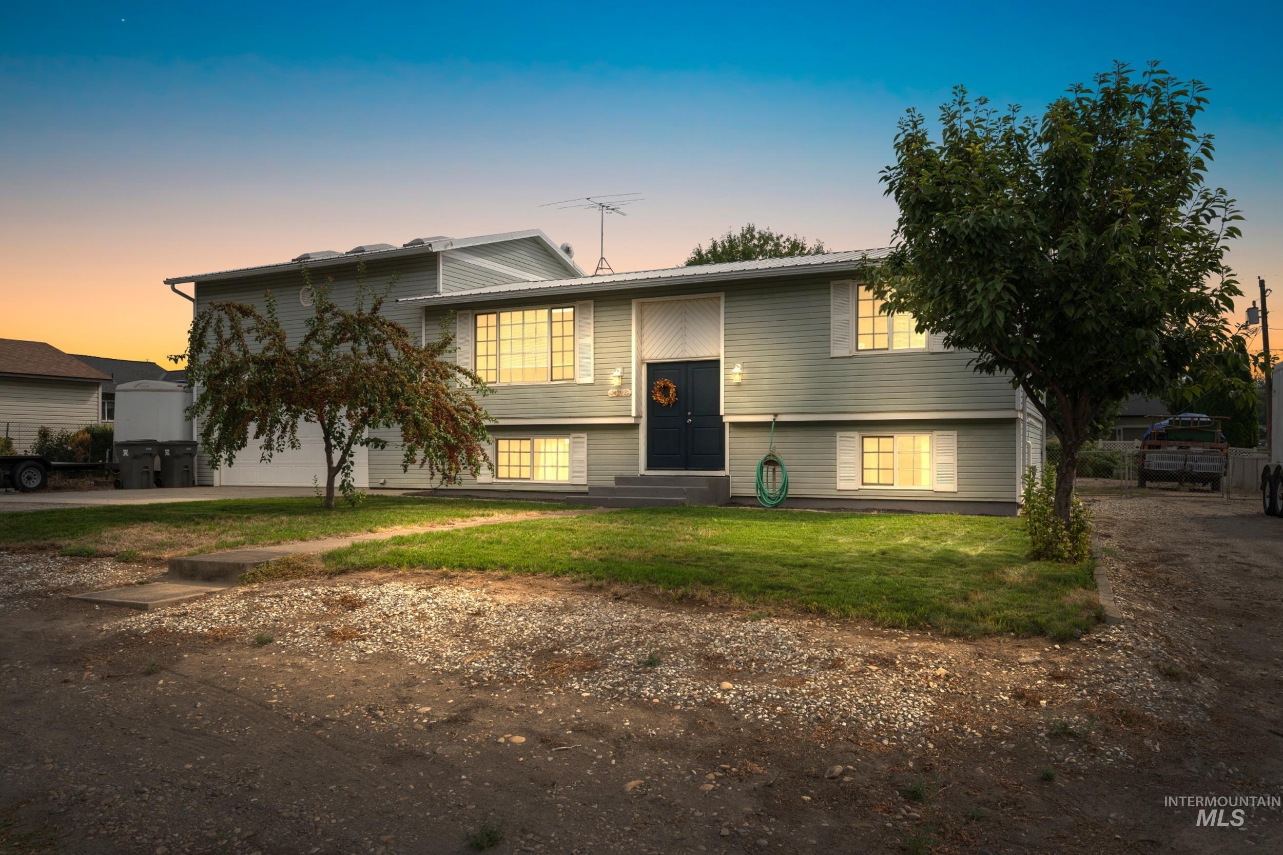Split foyer home featuring a lawn and dirt driveway