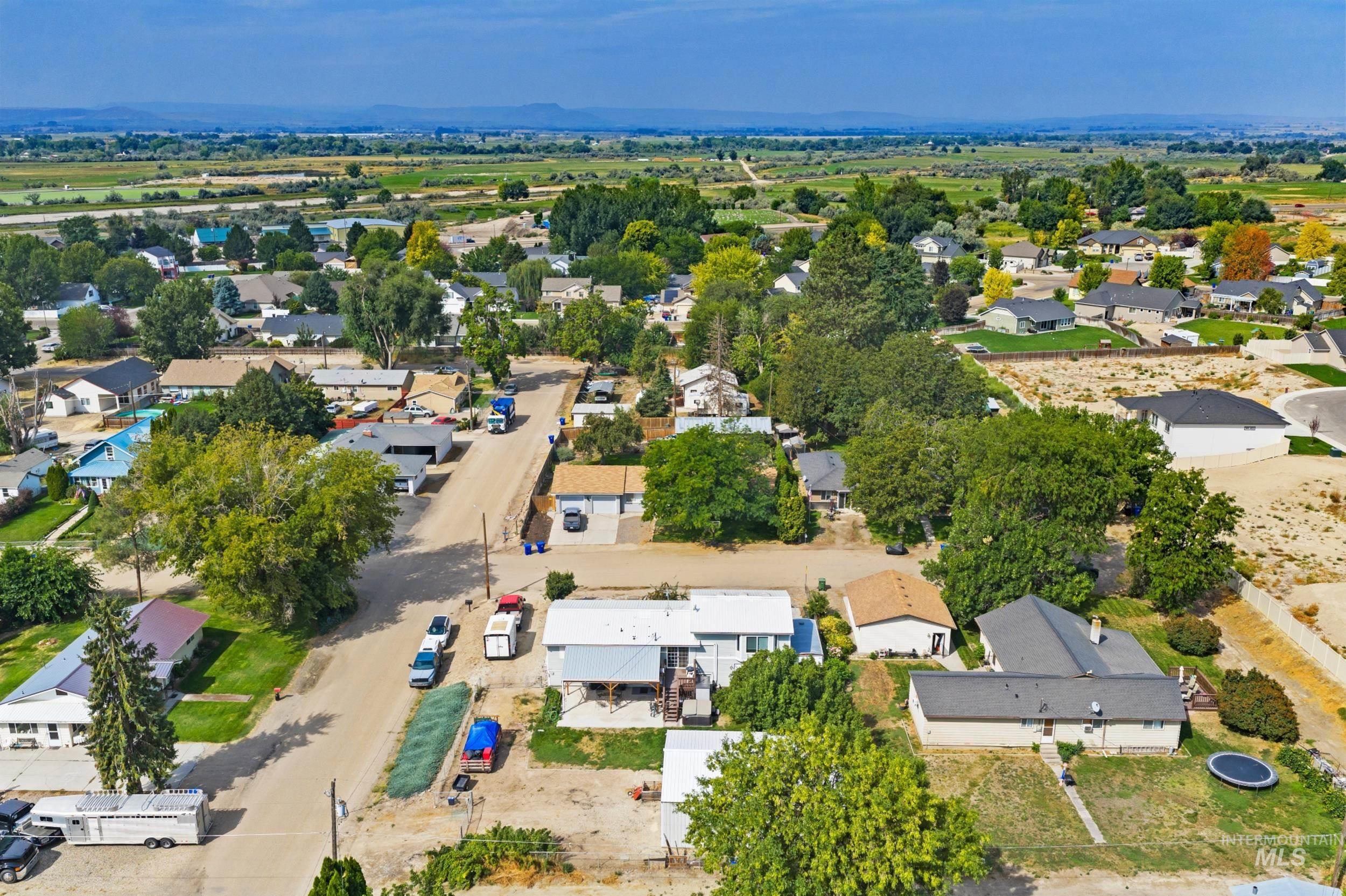Aerial view of property and surrounding area featuring nearby suburban area