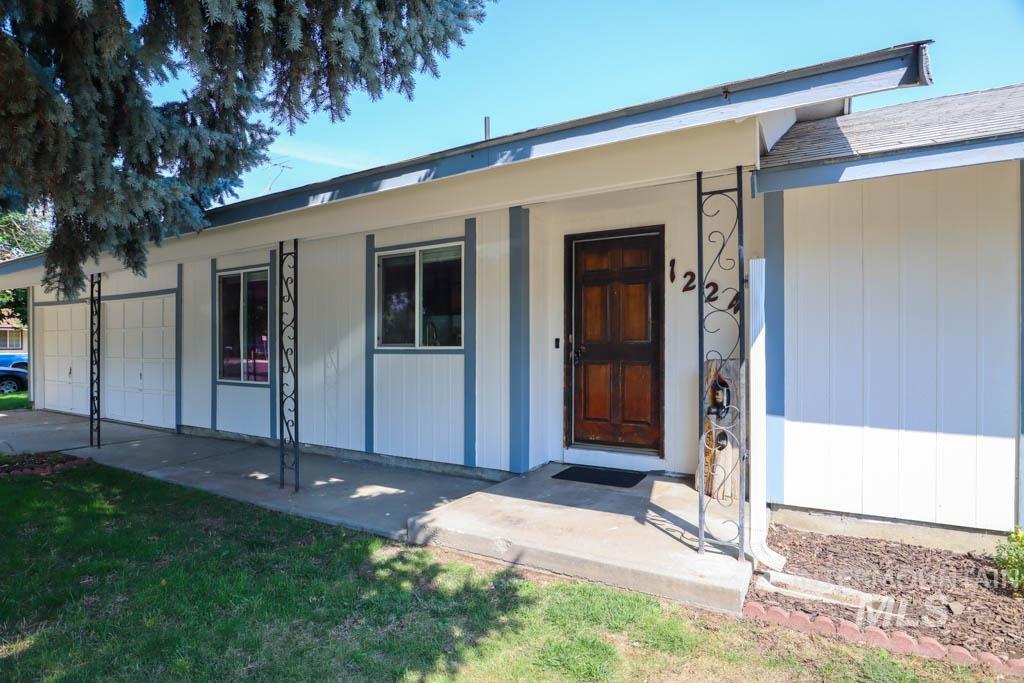 Property entrance with an attached garage and a yard