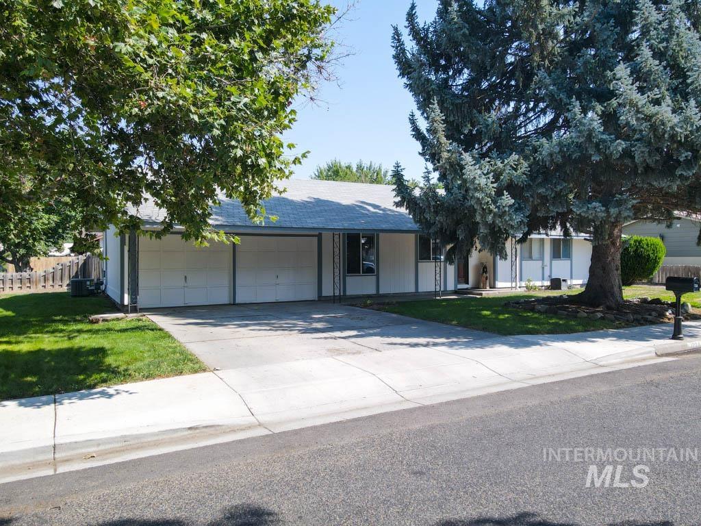 View of front of home with concrete driveway and a garage