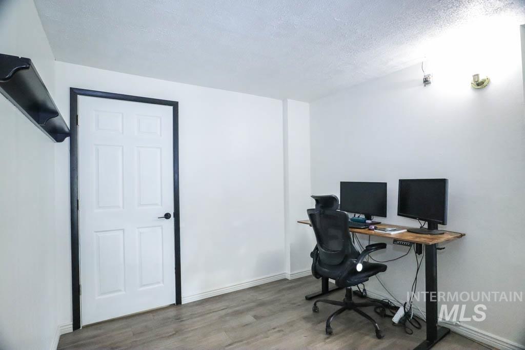 Office space featuring light wood-style flooring and a textured ceiling