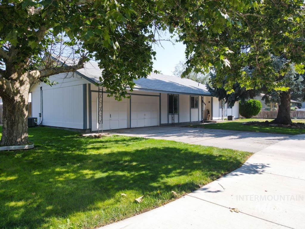 Ranch-style house featuring a front yard, an attached garage, and concrete driveway