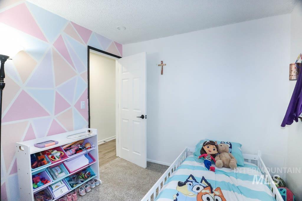 Bedroom featuring light colored carpet and a textured ceiling