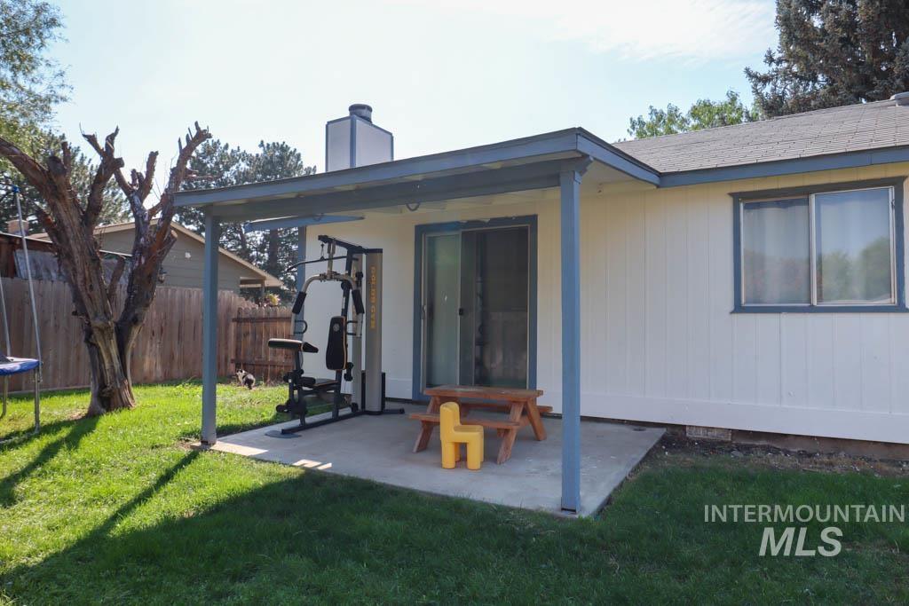 Rear view of property featuring a chimney and a patio area