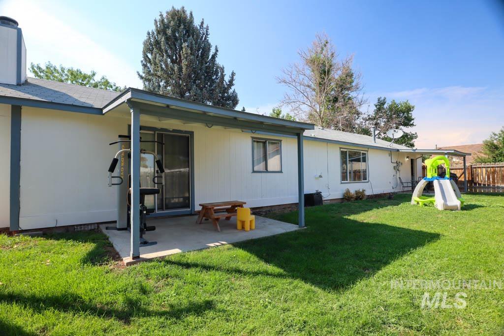 Back of house featuring a lawn and a patio