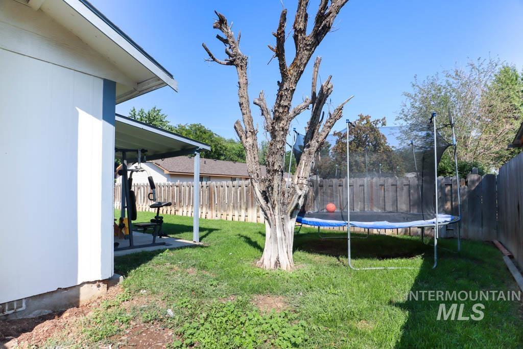 Fenced backyard with a patio and a trampoline