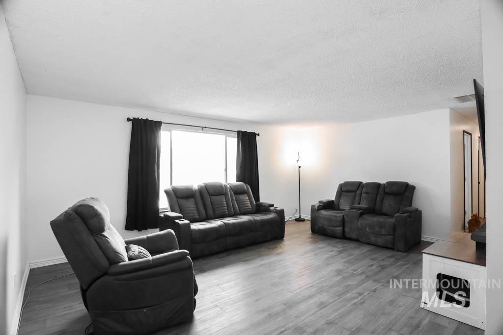 Living area with wood finished floors and a textured ceiling