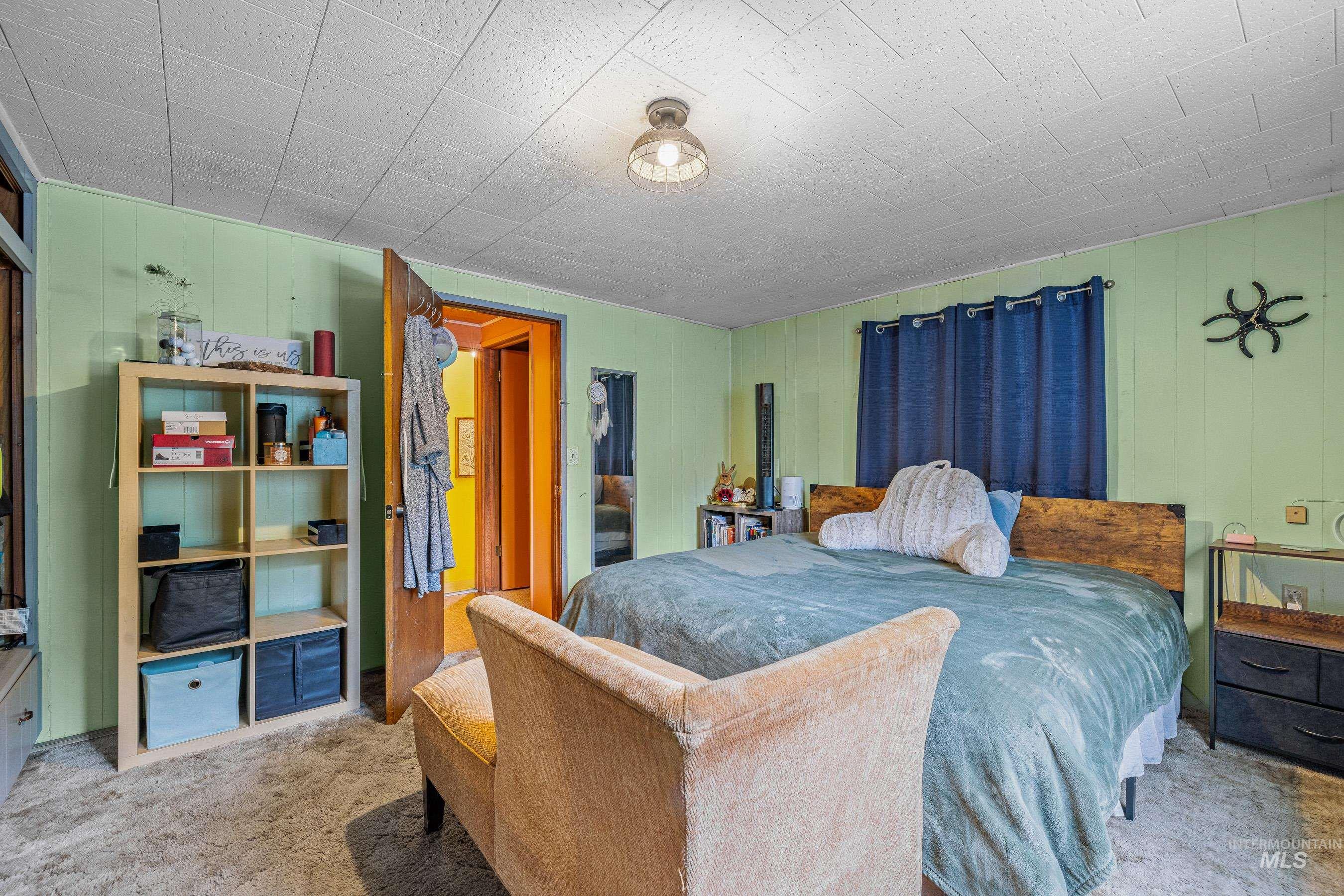 Carpeted bedroom with wood walls