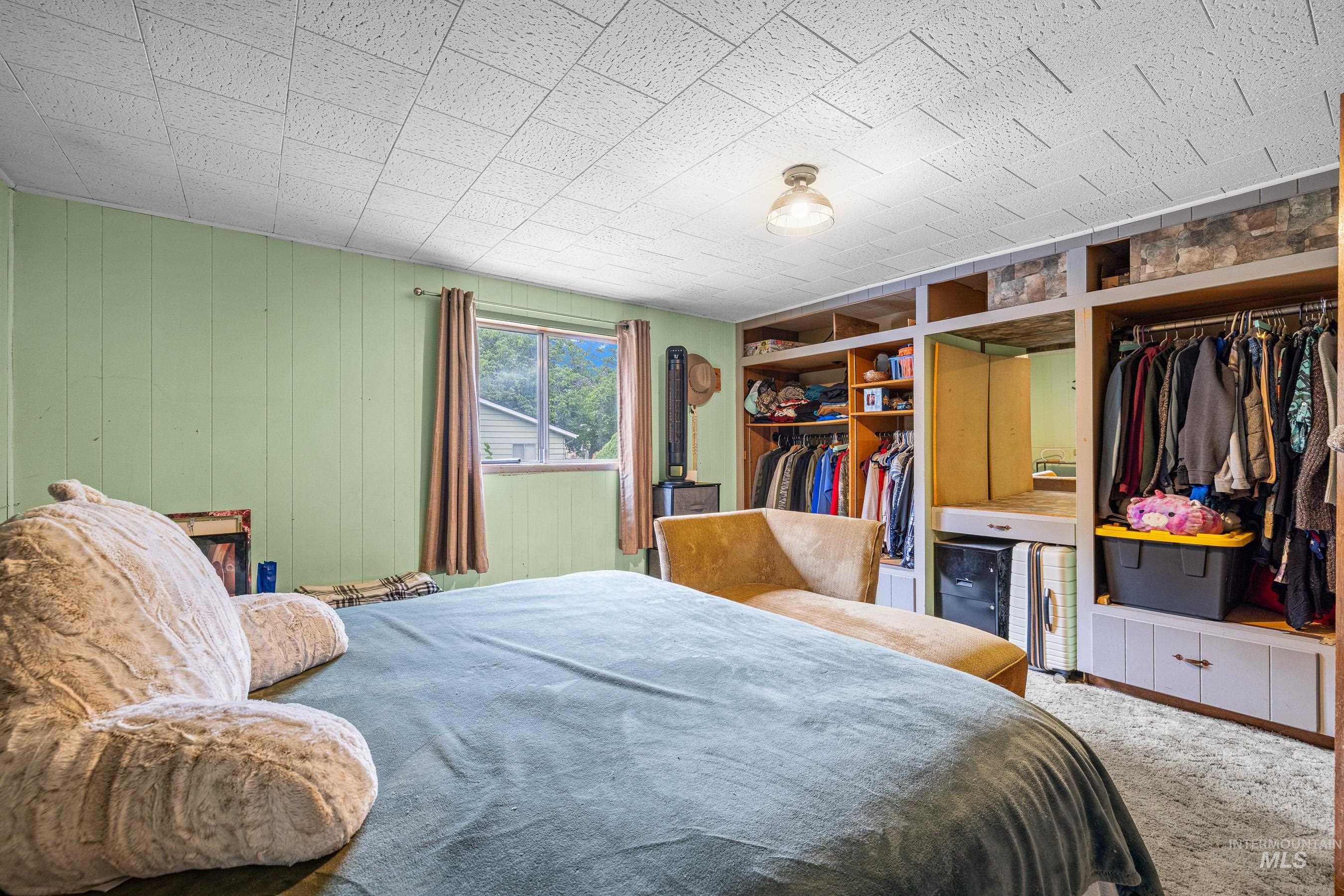 Bedroom featuring a closet, carpet floors, and wooden walls
