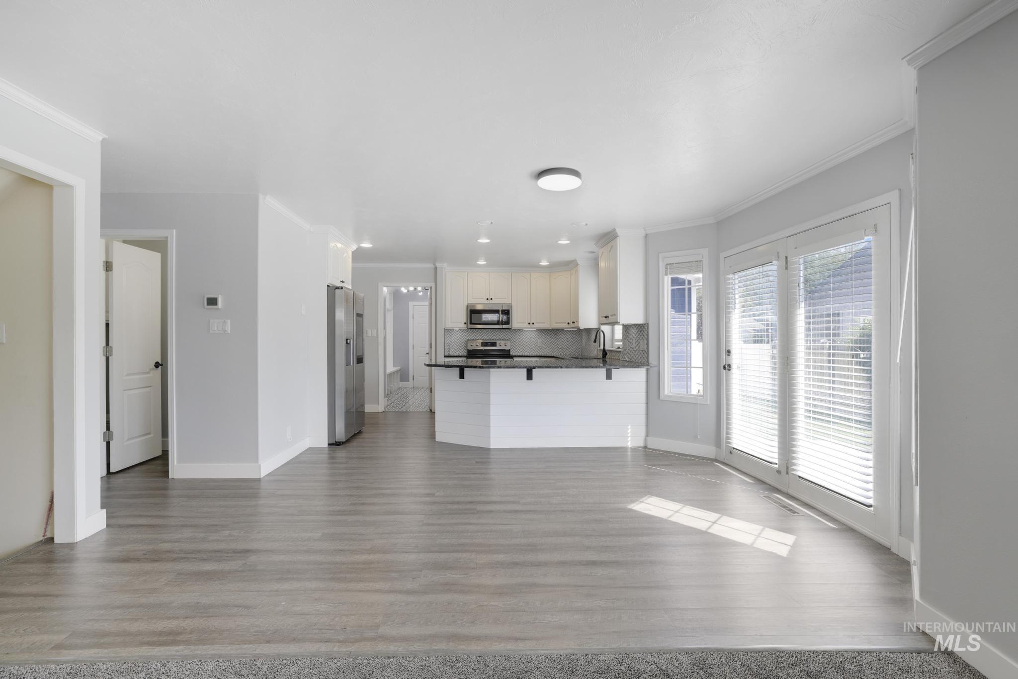 Unfurnished living room with crown molding and dark wood finished floors