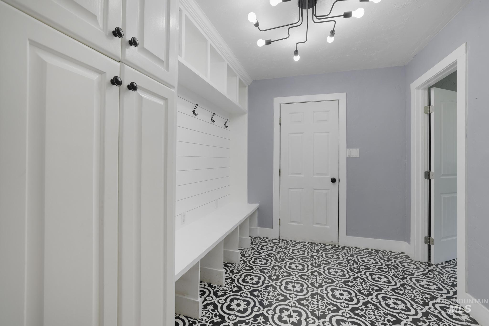 Mudroom with tile patterned flooring and a chandelier