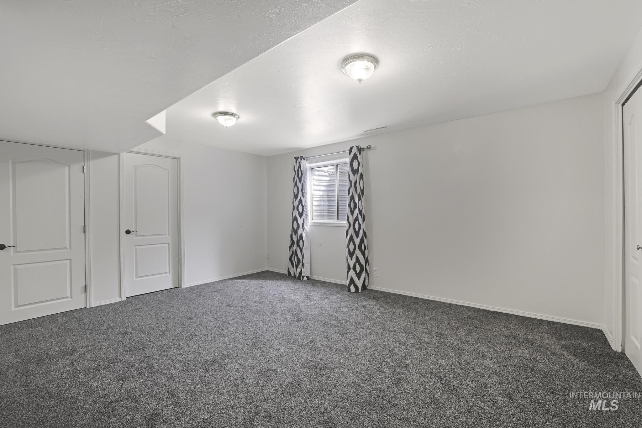 Unfurnished bedroom featuring dark carpet and a closet