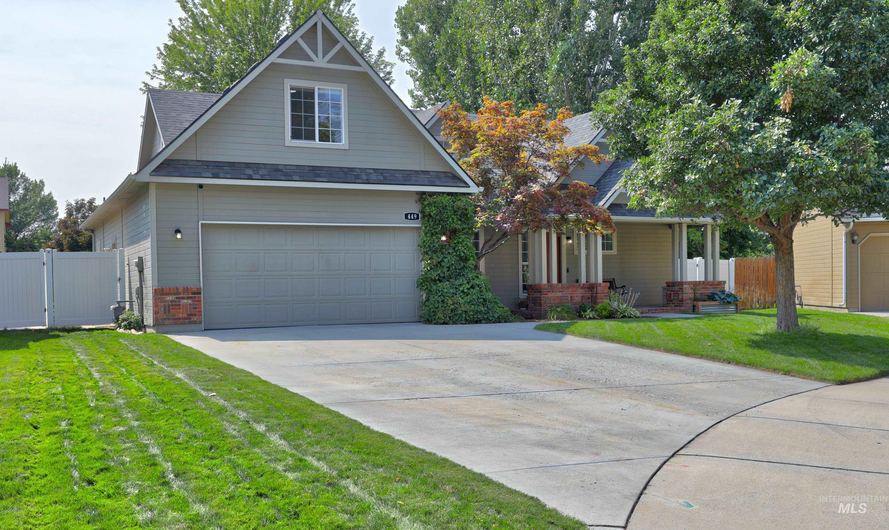 View of front of home with driveway, a gate, and roof with shingles