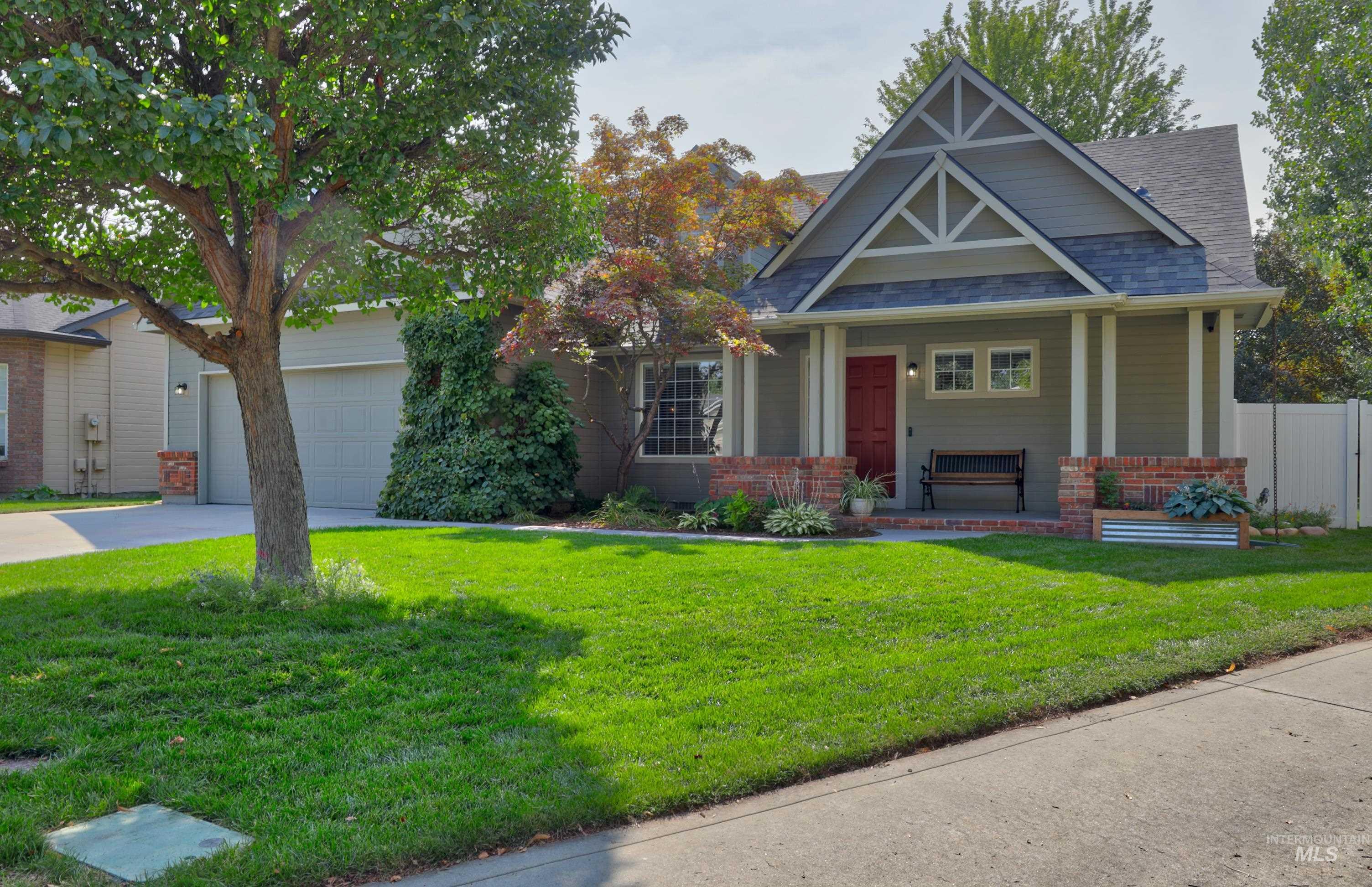 Craftsman-style house featuring covered porch, concrete driveway, a front yard, roof with shingles, and an attached garage