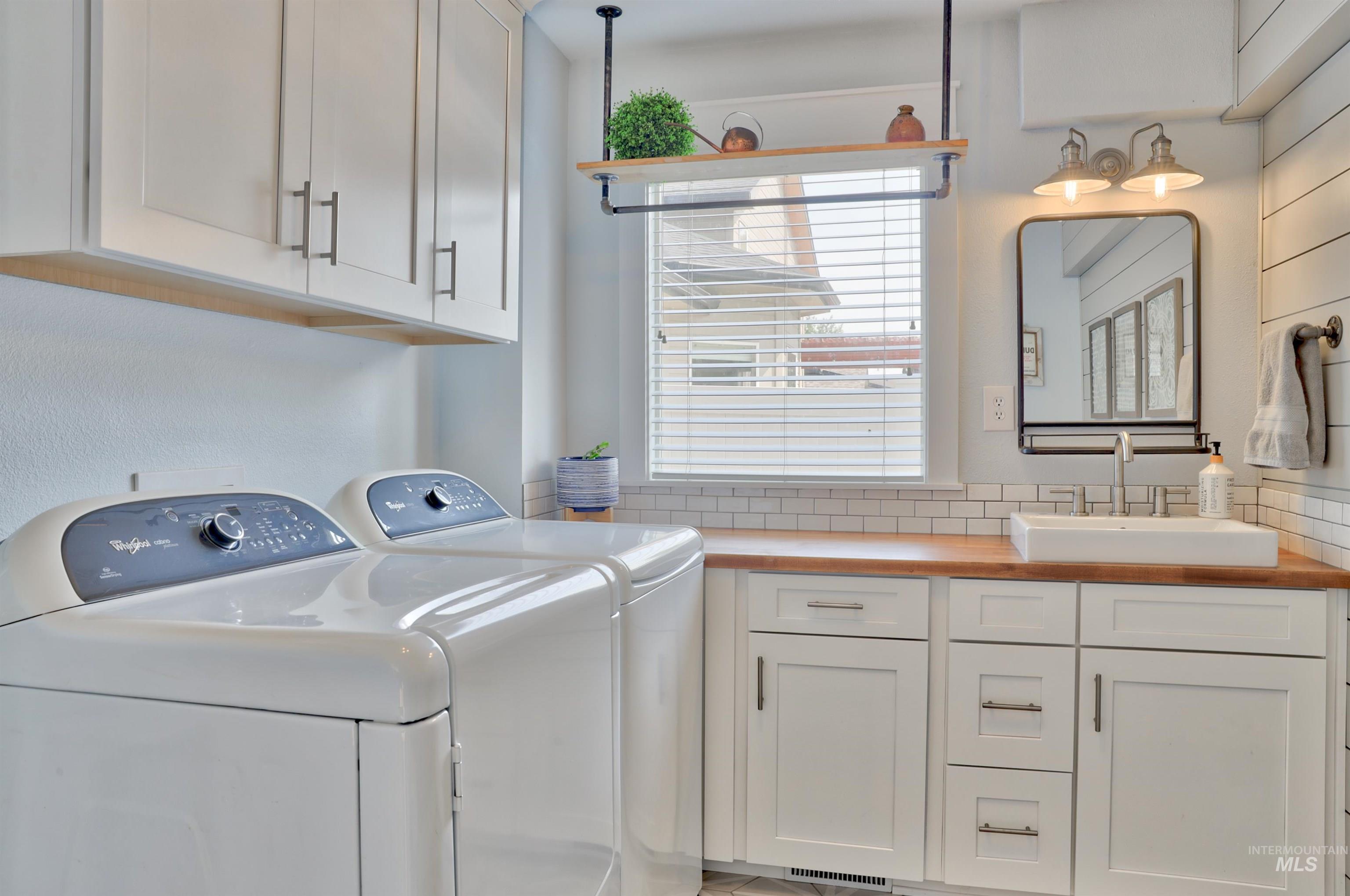 Laundry area featuring washing machine and clothes dryer and cabinet space