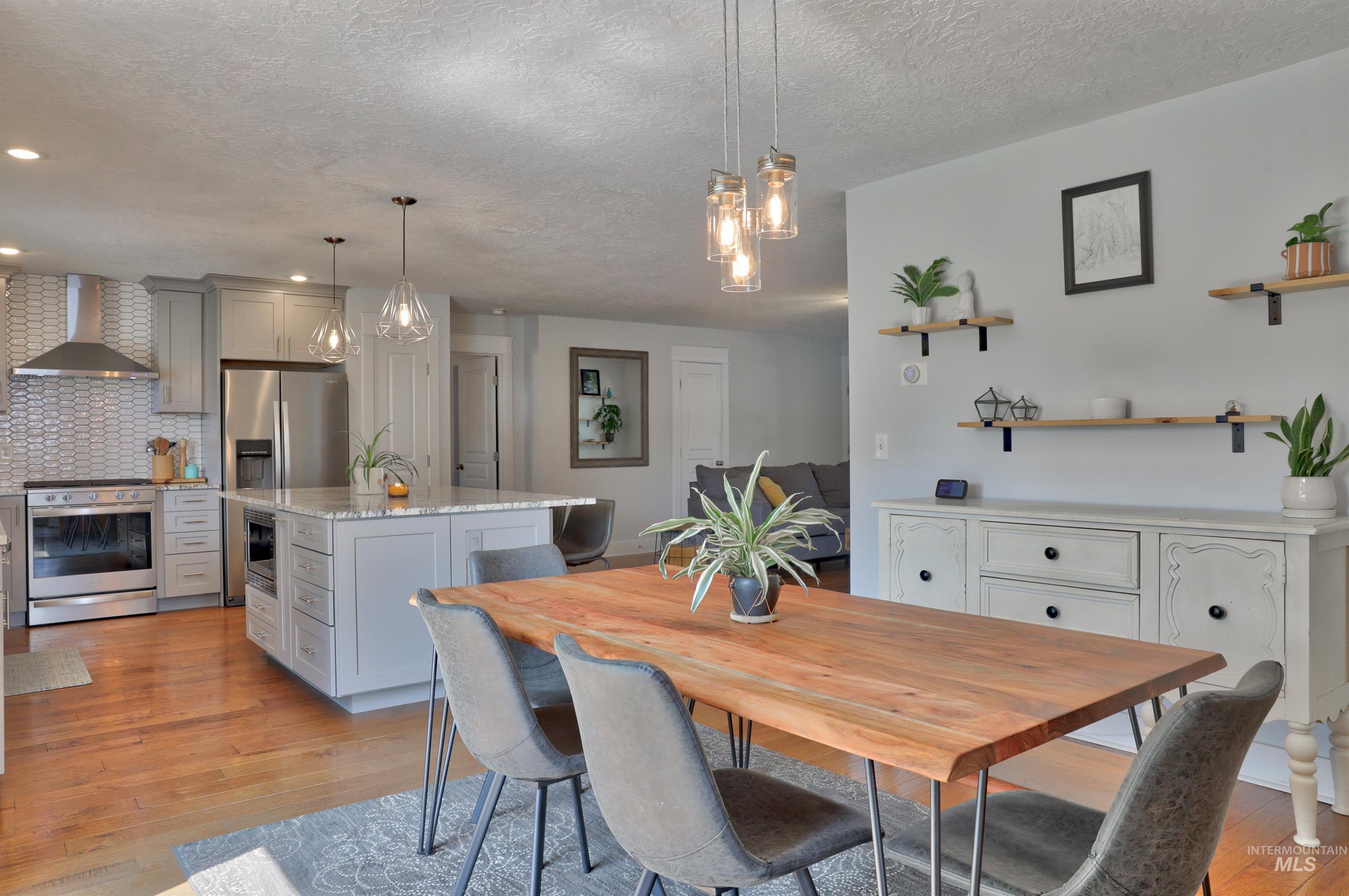 Dining space featuring light wood-type flooring and a textured ceiling