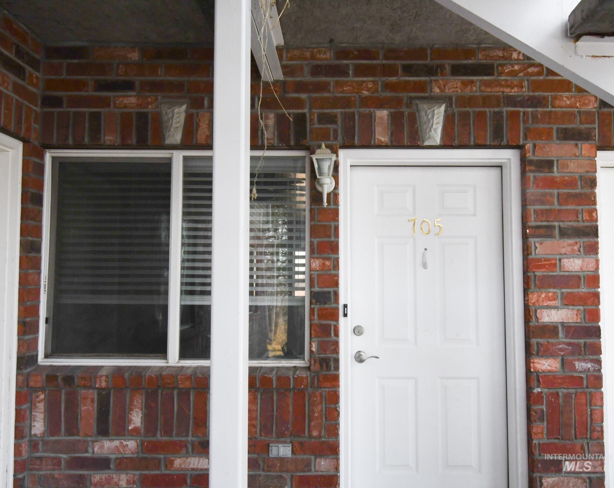 Entrance to property featuring brick siding