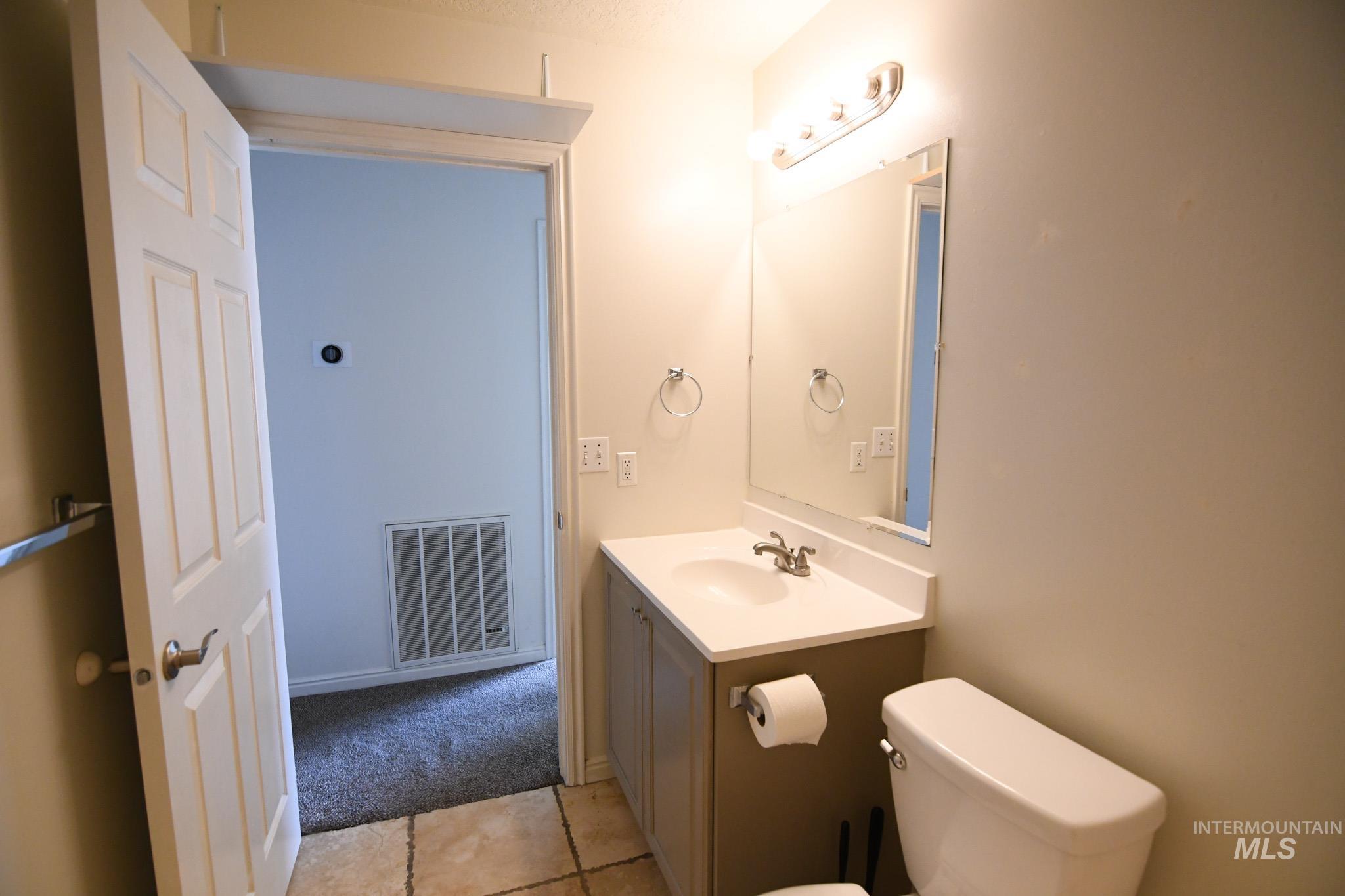 Half bathroom with vanity and light tile patterned flooring