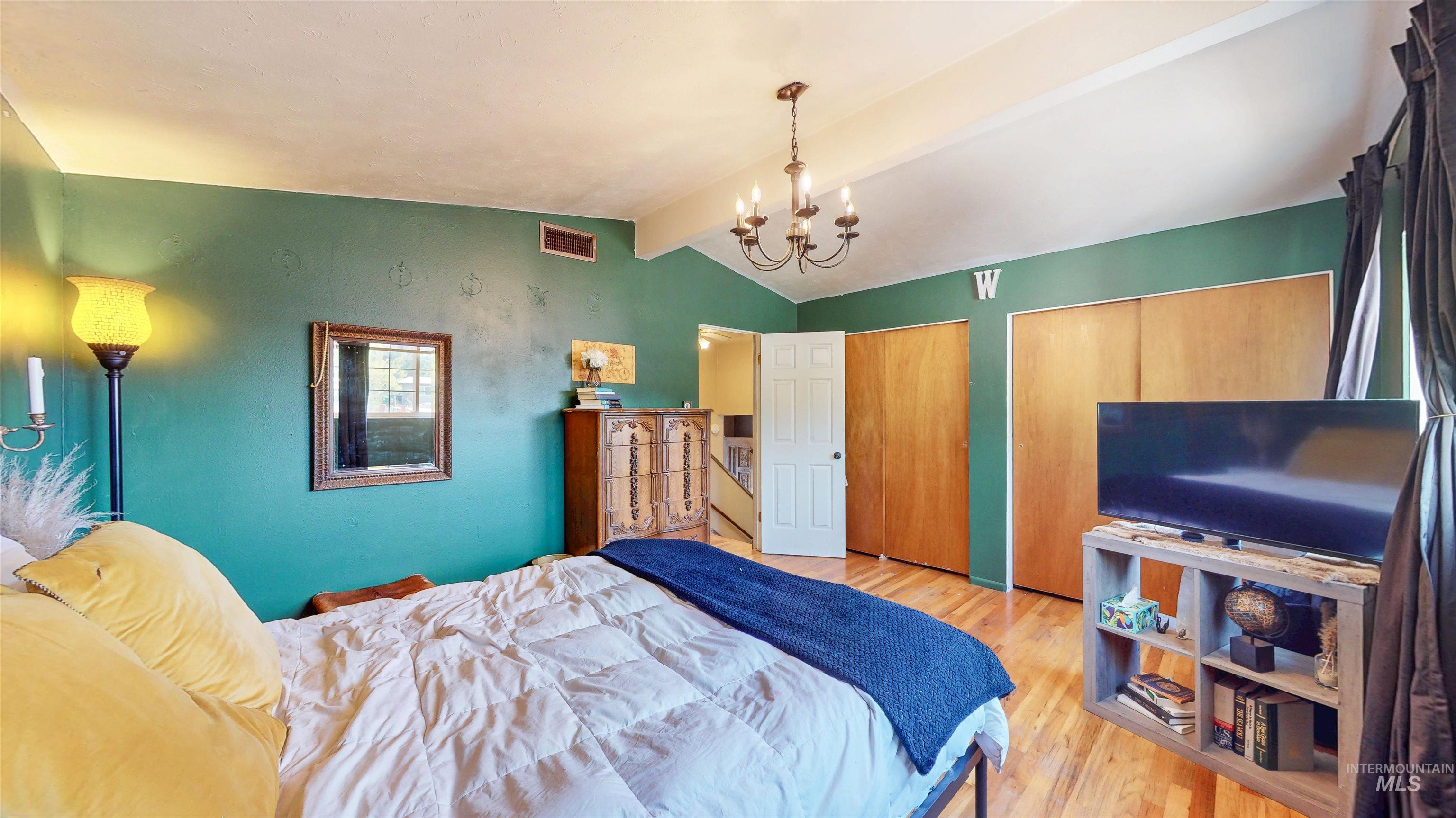 Bedroom with light wood-type flooring and a chandelier