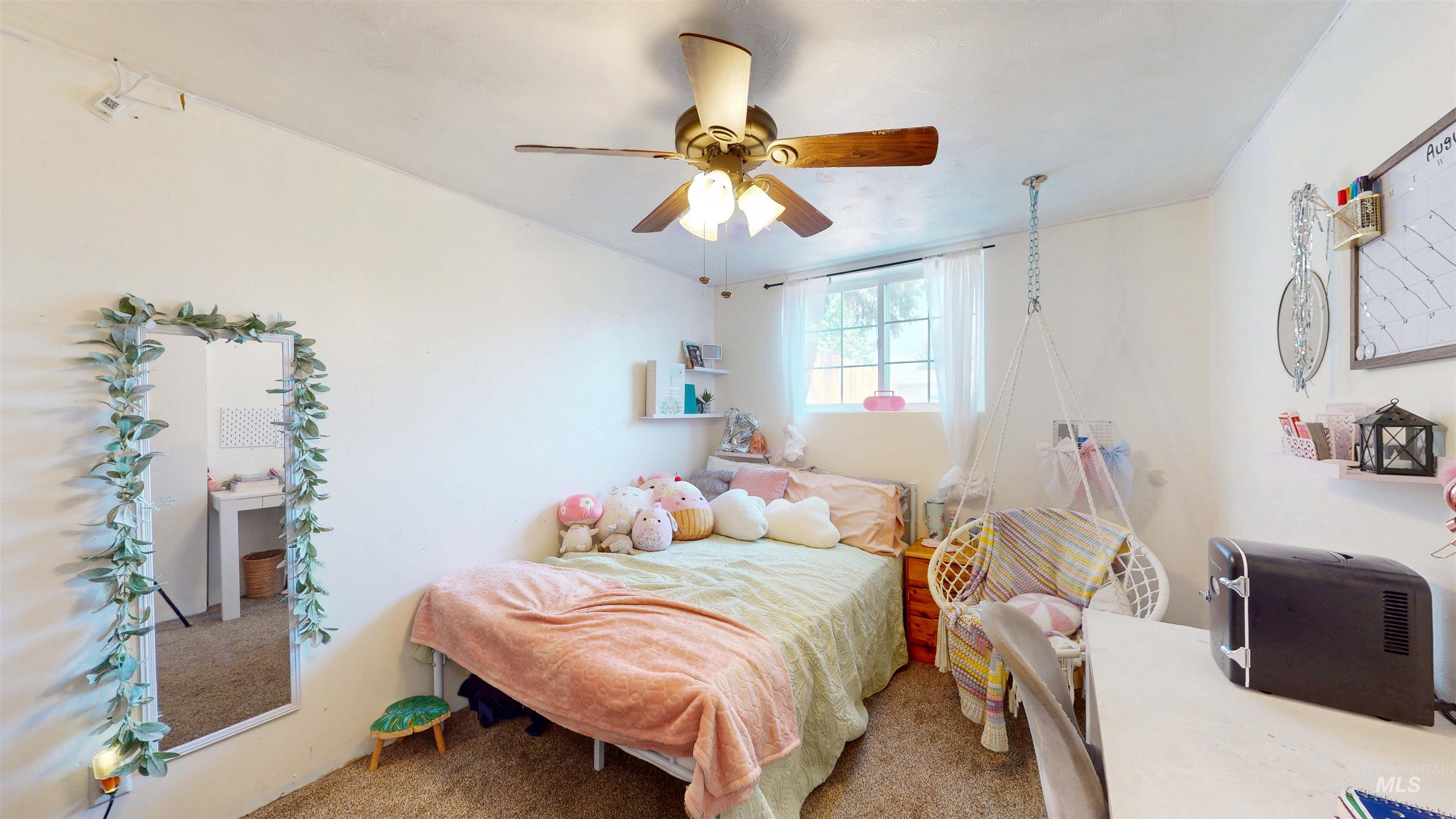 Carpeted bedroom featuring a ceiling fan