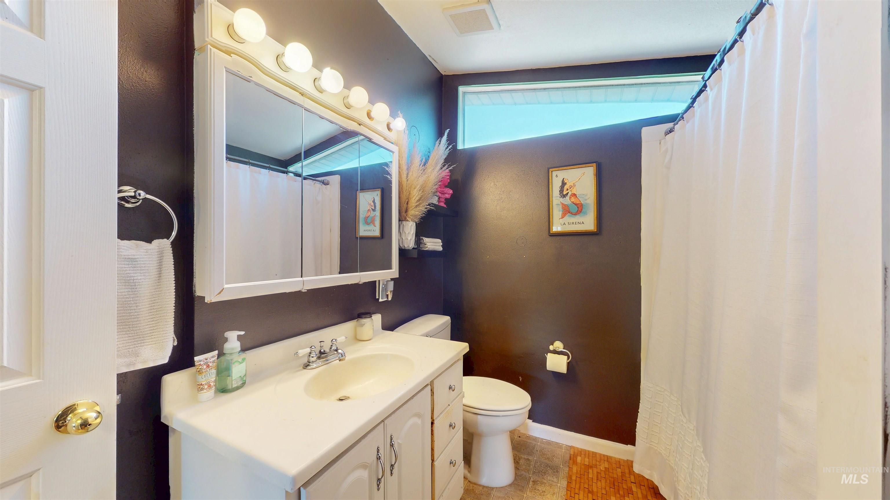 Bathroom featuring vanity, light tile patterned floors, and a shower with curtain