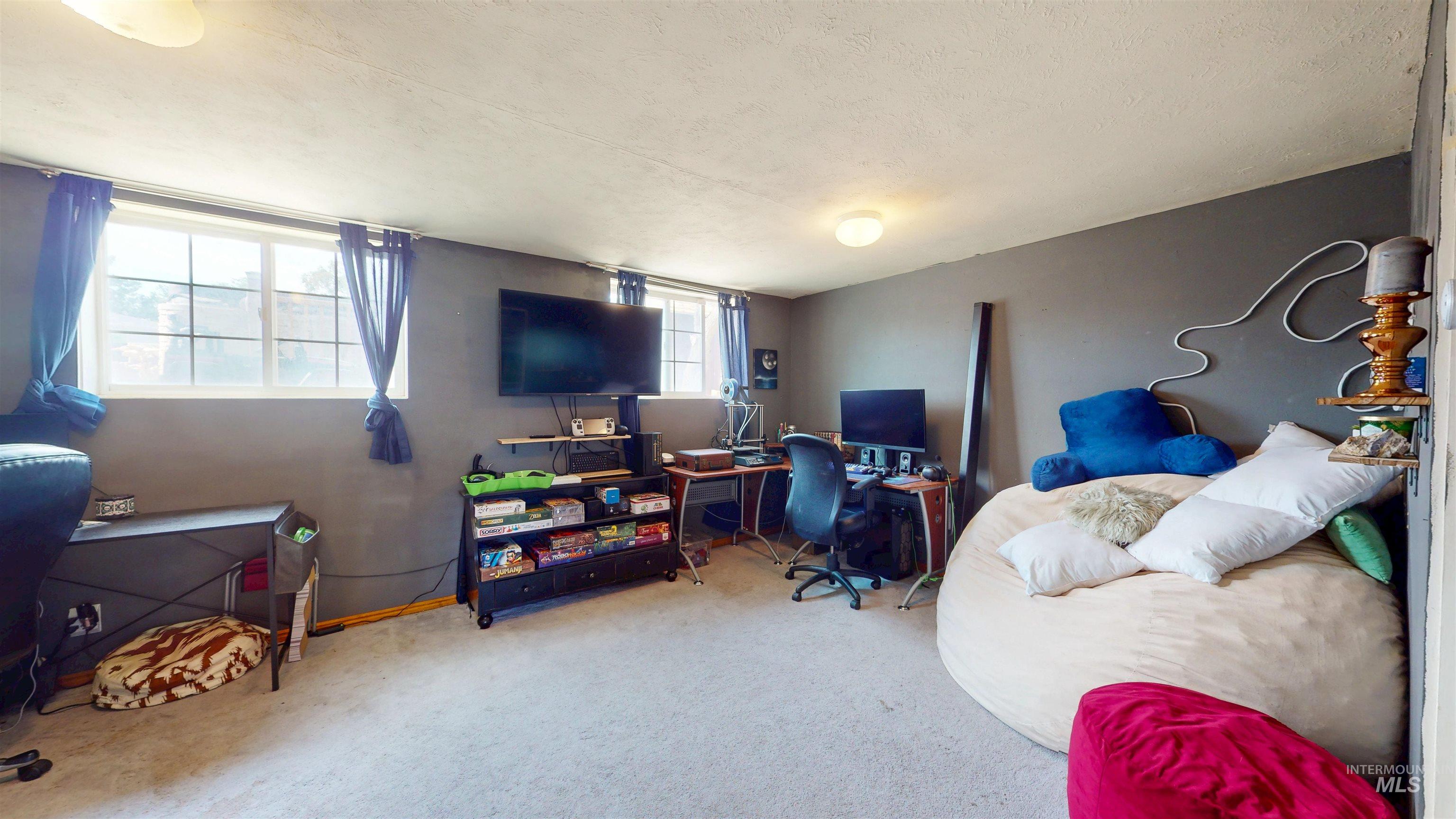 Carpeted home office featuring a textured ceiling