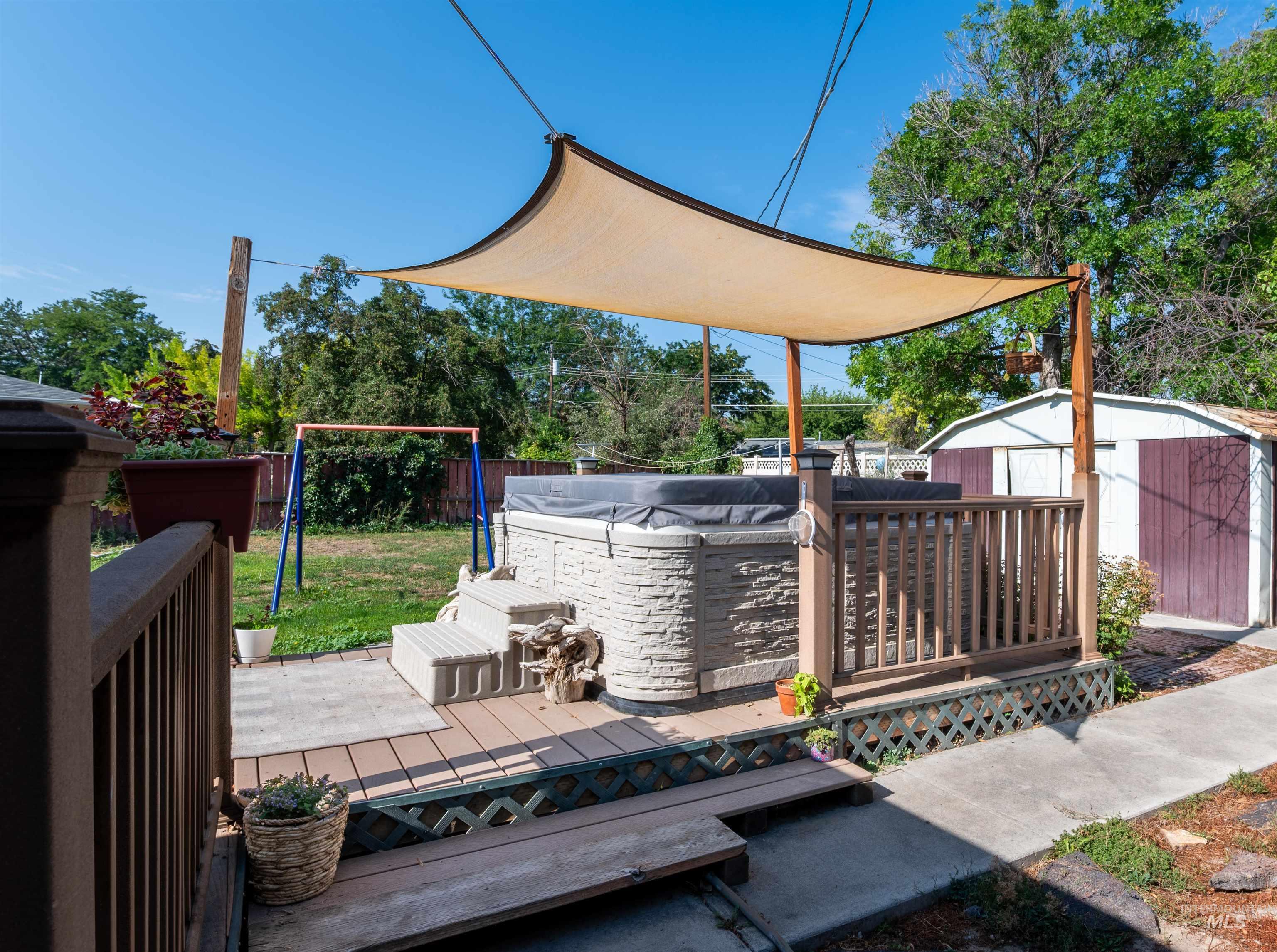 Wooden terrace featuring a shed and a fenced backyard