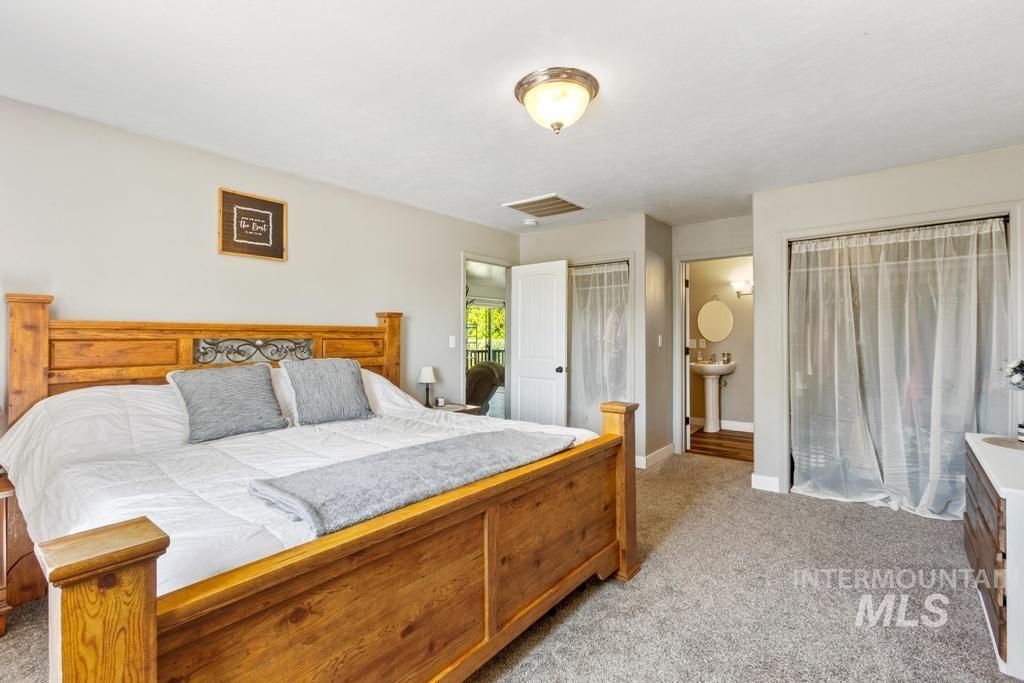Bedroom featuring light carpet and two closets