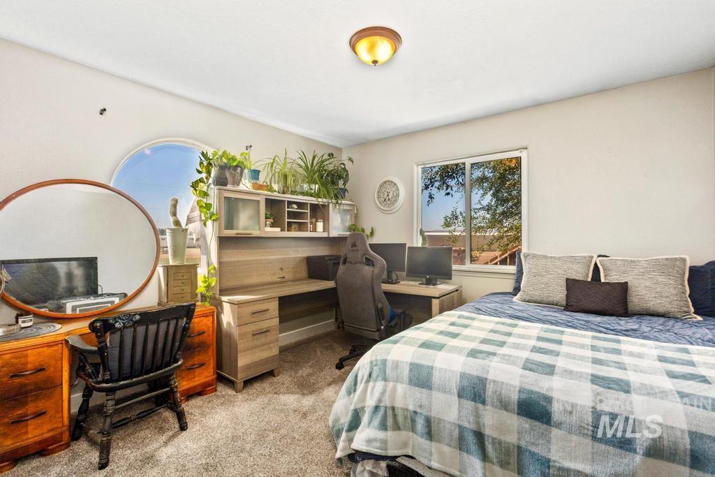 Bedroom with light colored carpet and a desk