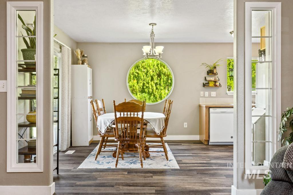 Dining room featuring dark wood finished floors and a chandelier
